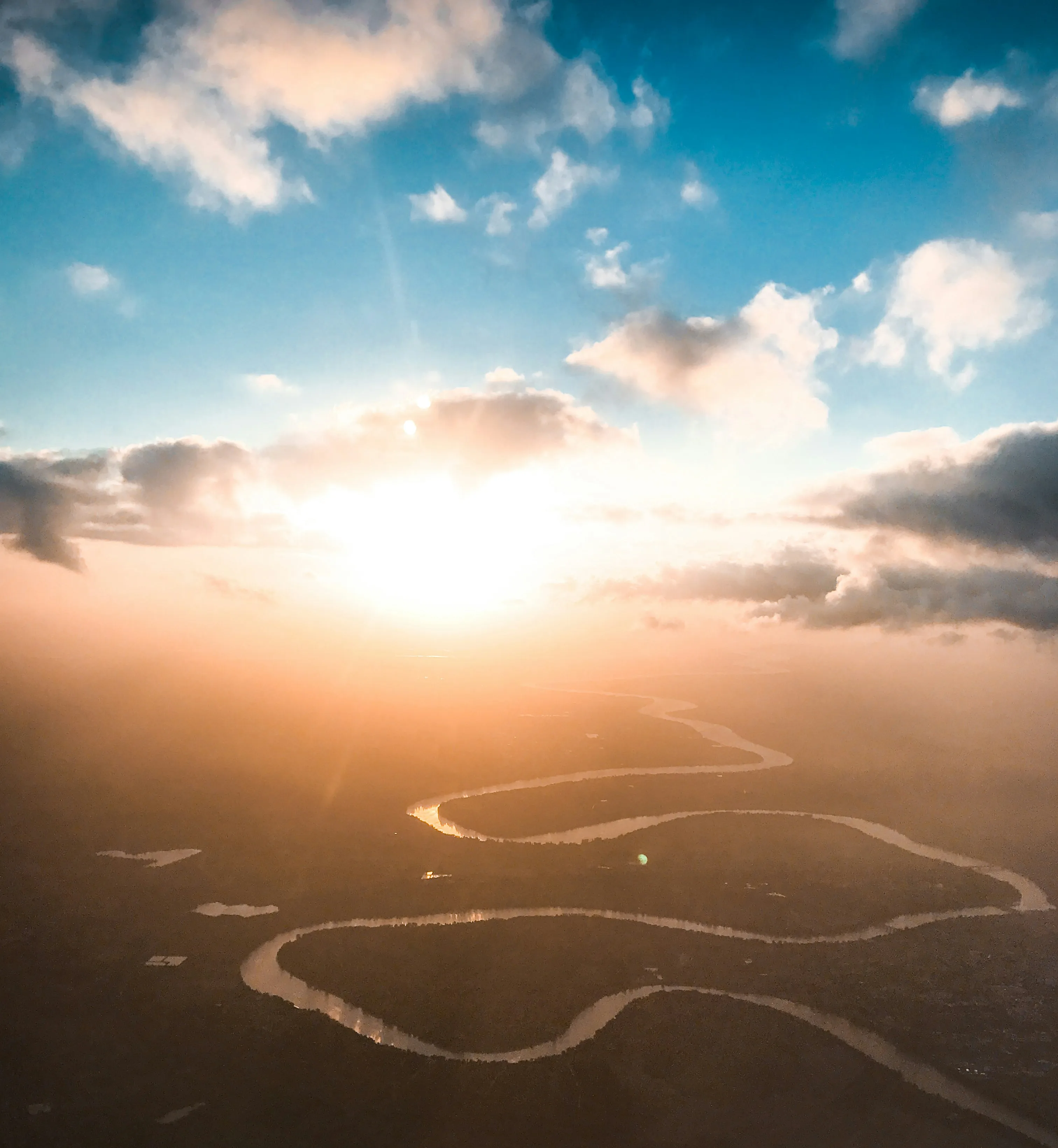 Golden Sunlight Over Serene Landscape with Winding River