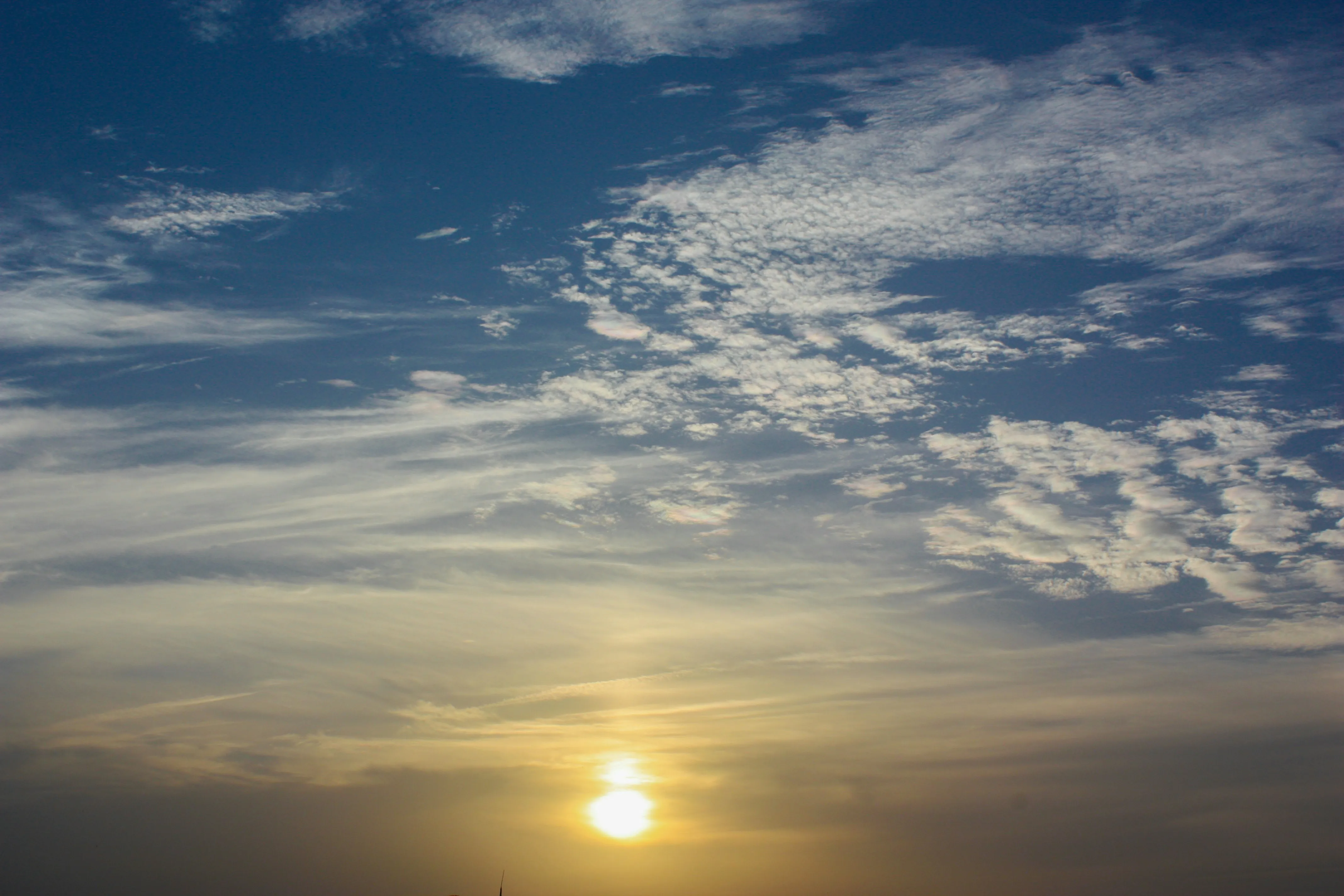 Golden Sunrise Over Calm Sea with Scattered Clouds Image