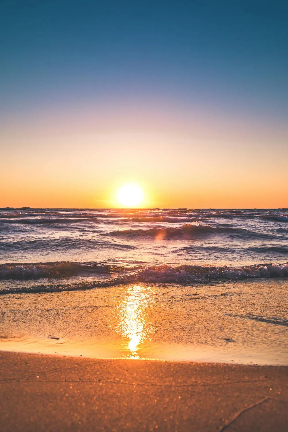 Golden Sunset Over Calm Ocean Waves on the Beach Image