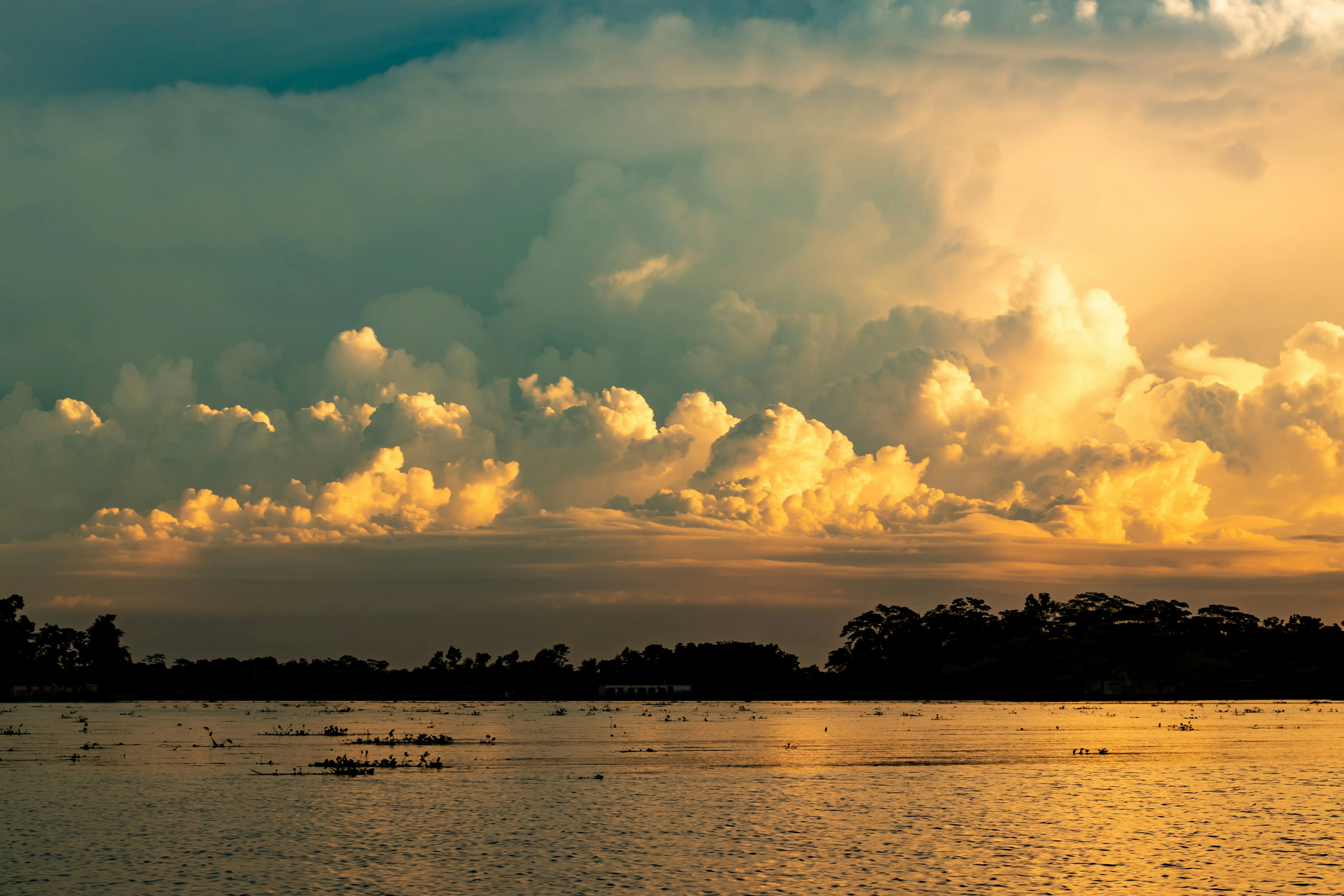 Golden Sunset Sky with Cloud Layers Over Distant Lake