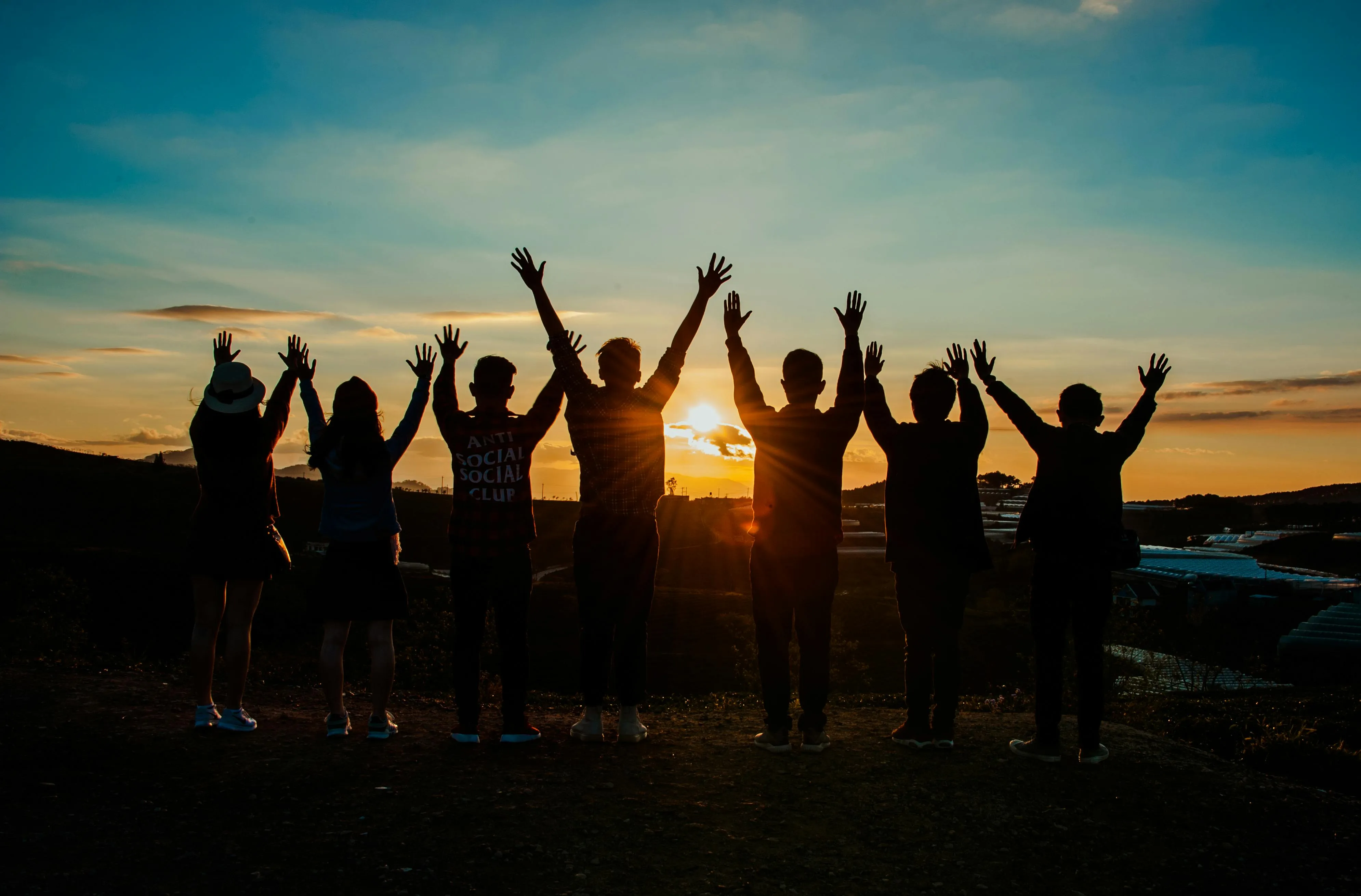 Group of People Celebrating Sunset in Open Field Wallpaper