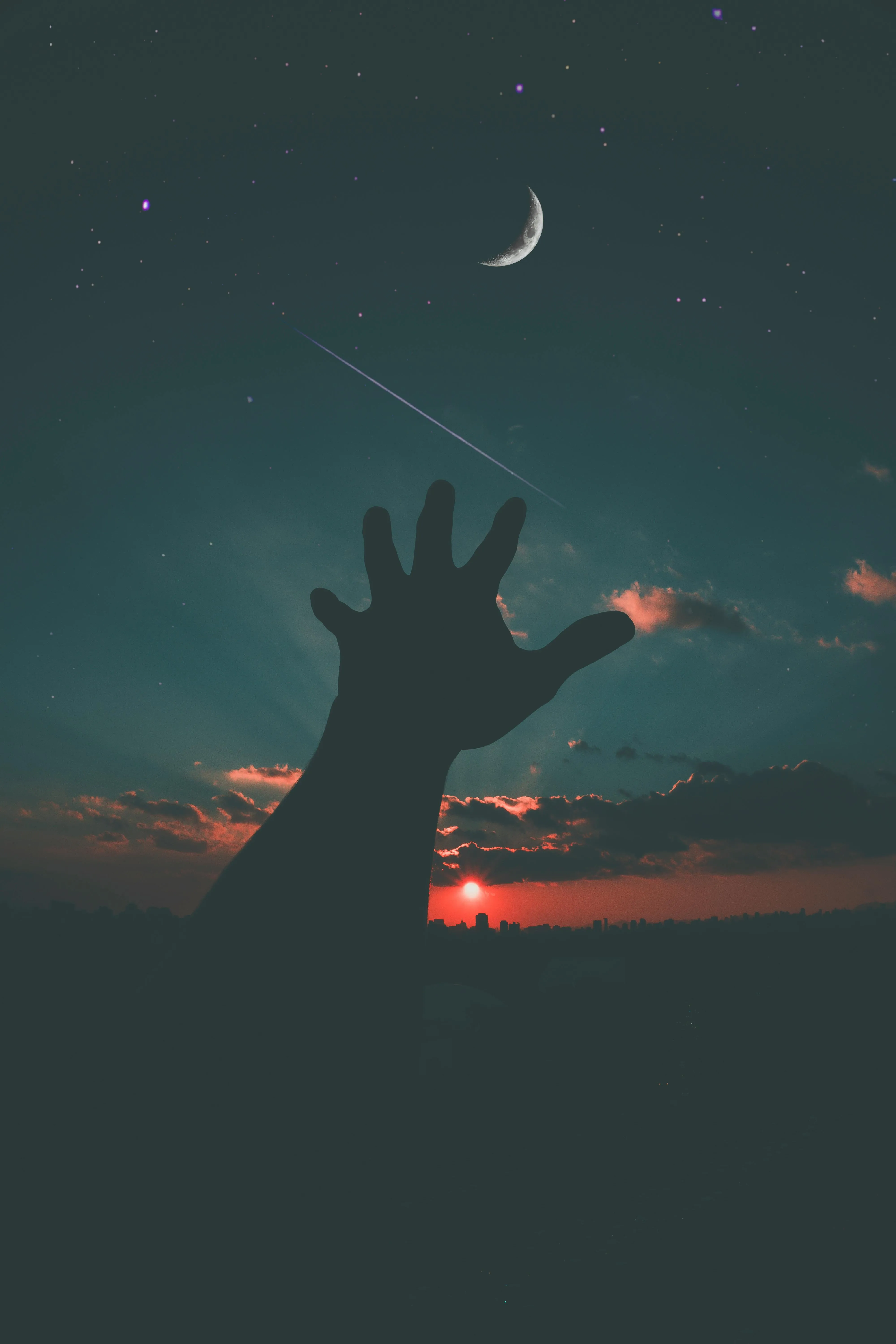 Hand Reaching Up at Sunset with Small Crescent Moon