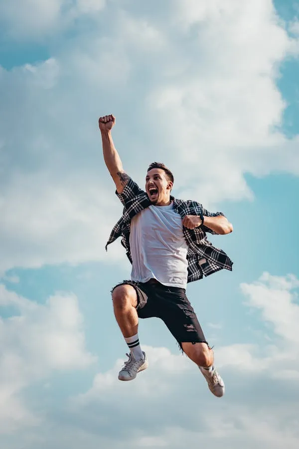 Happy Person Jumping with Joy Under Bright Blue Sky