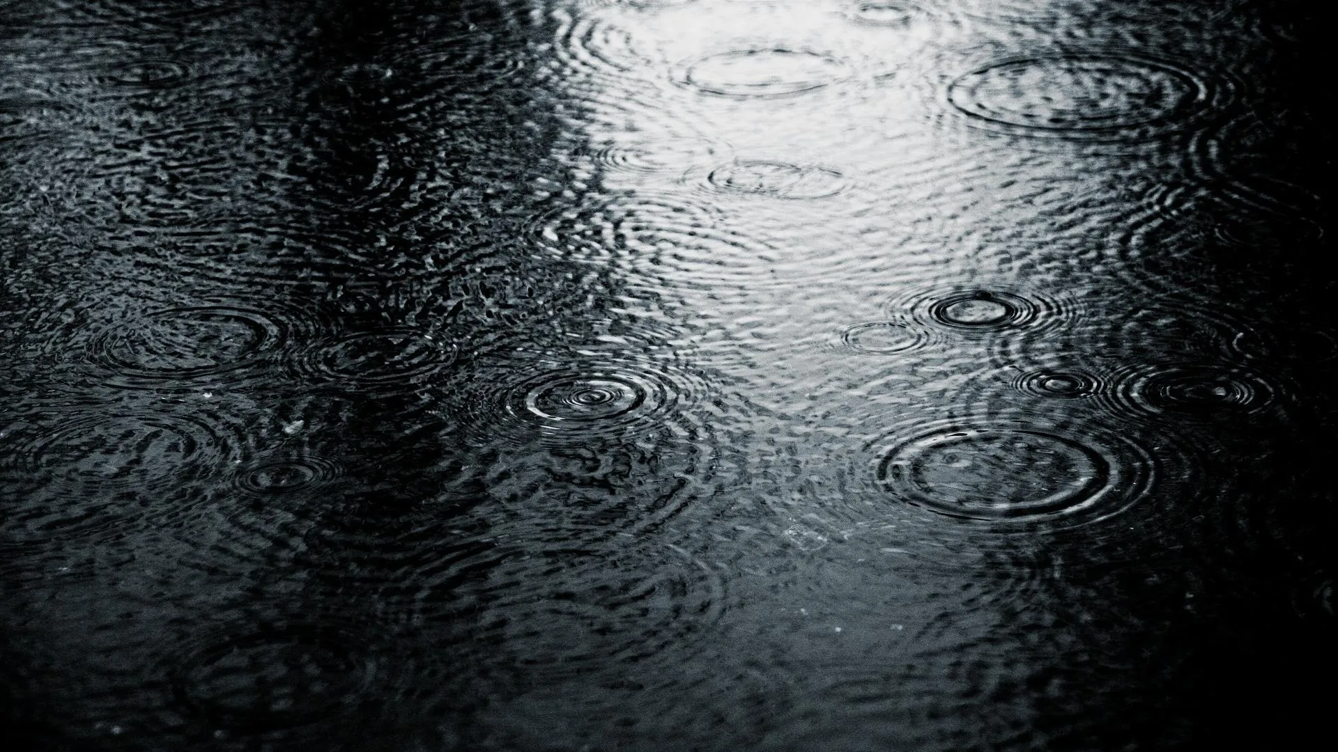 Heavy Rain Splashing on Black Reflective Surface