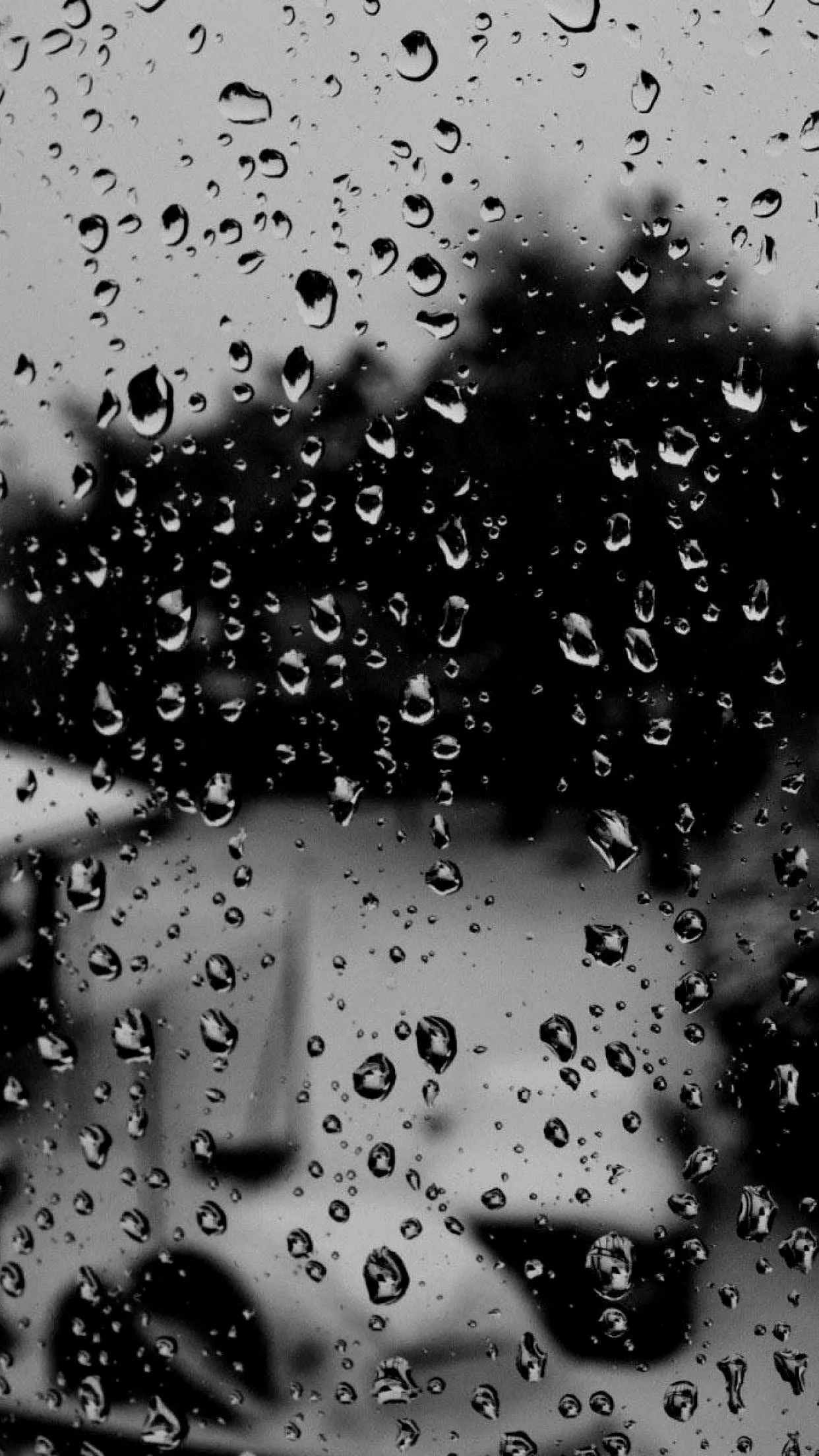 Heavy Raindrops Falling on Dark Reflective Surface