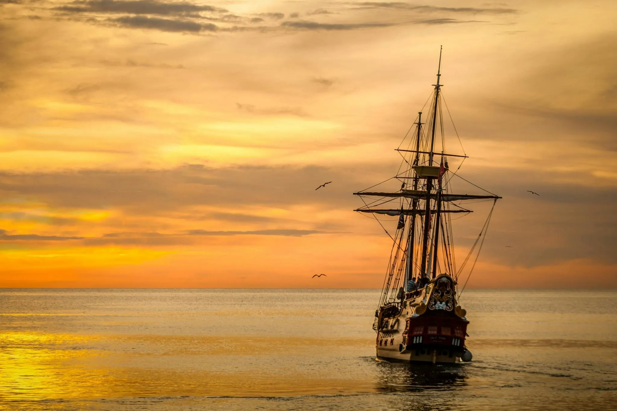 Historic Sailing Ship Sailing Under Warm Sunset Sky Image