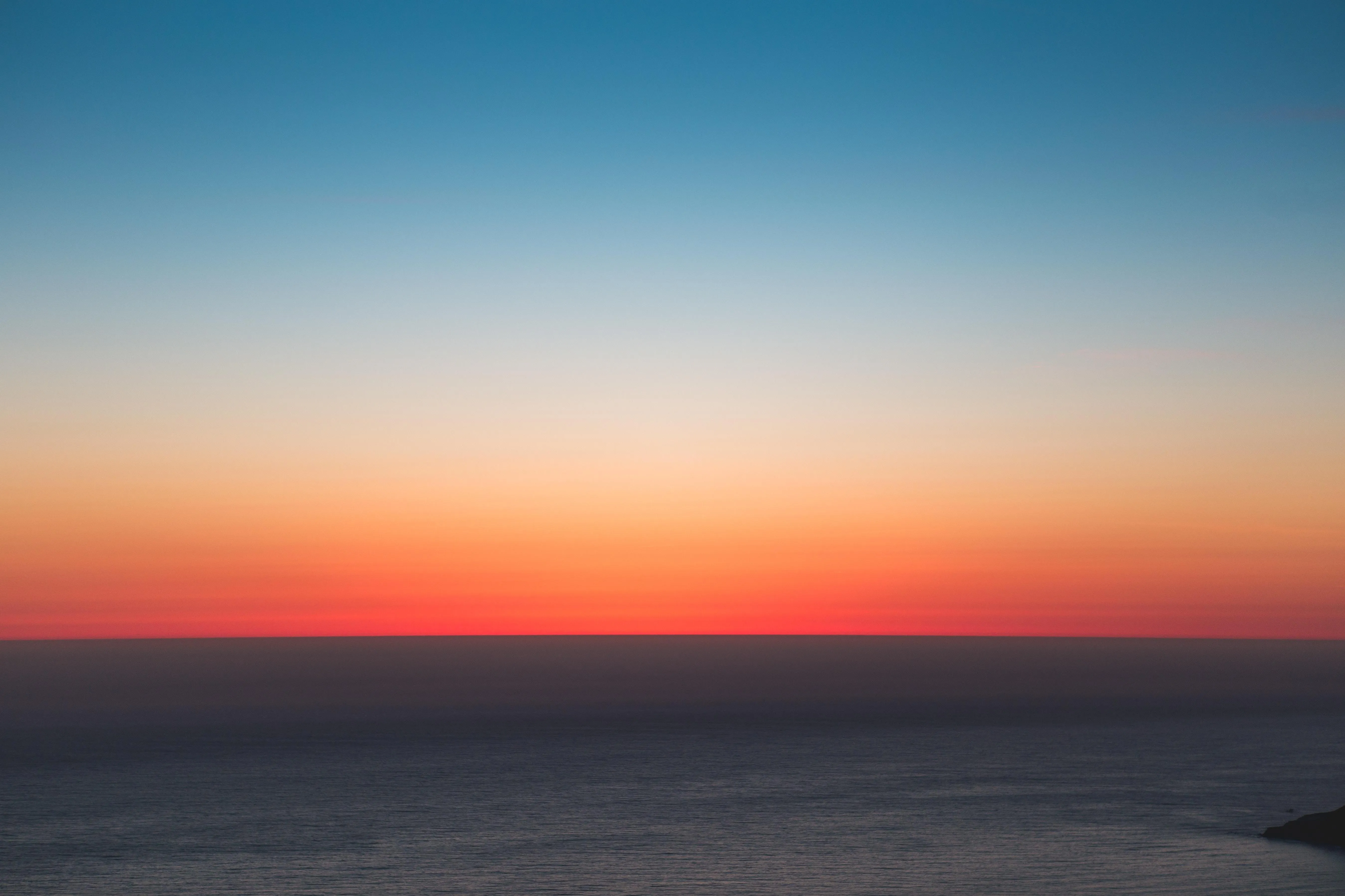 Horizon view of a deep red and orange sunset free Wallpaper
