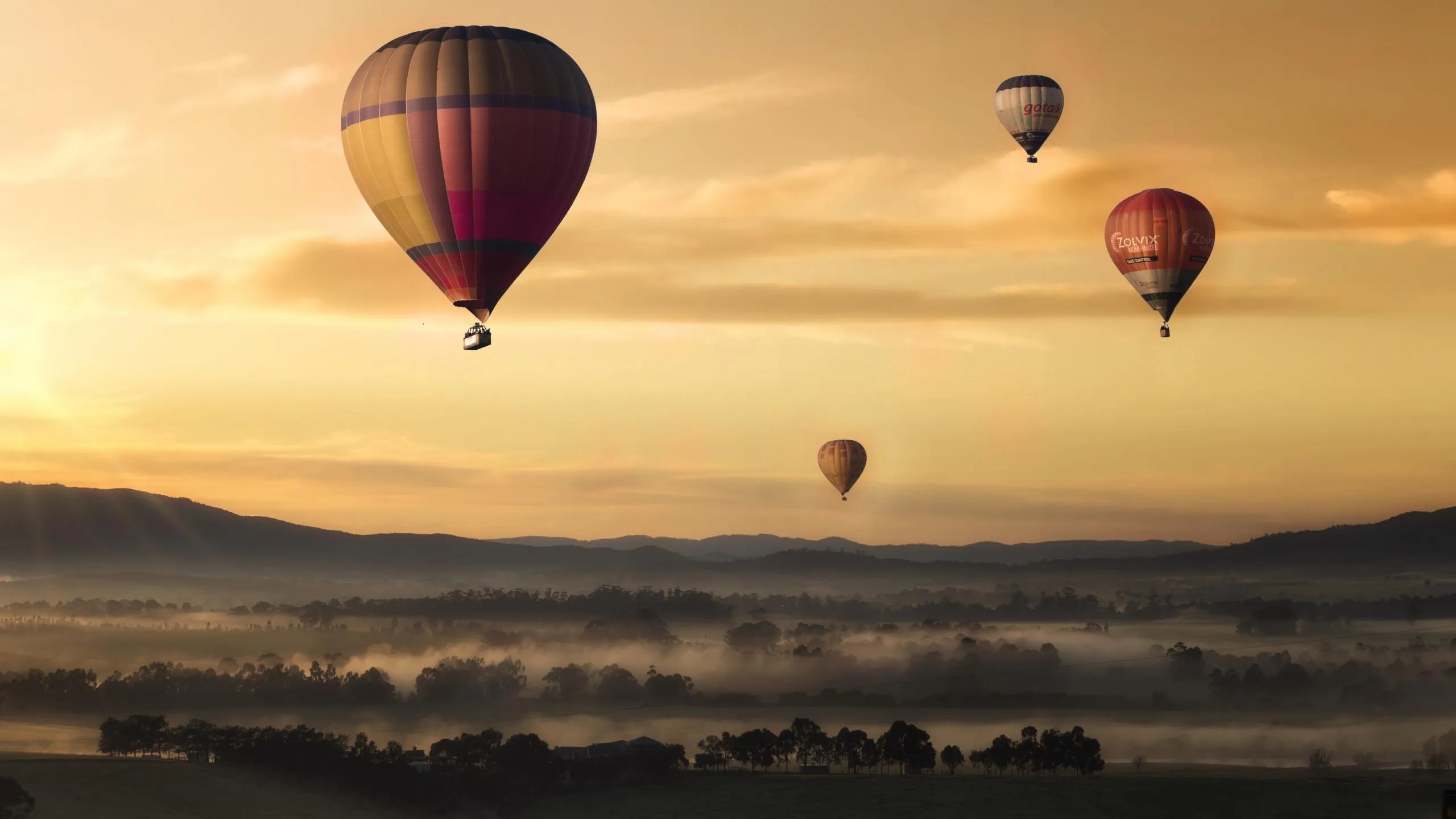 Hot air balloons floating over desert dunes HD image