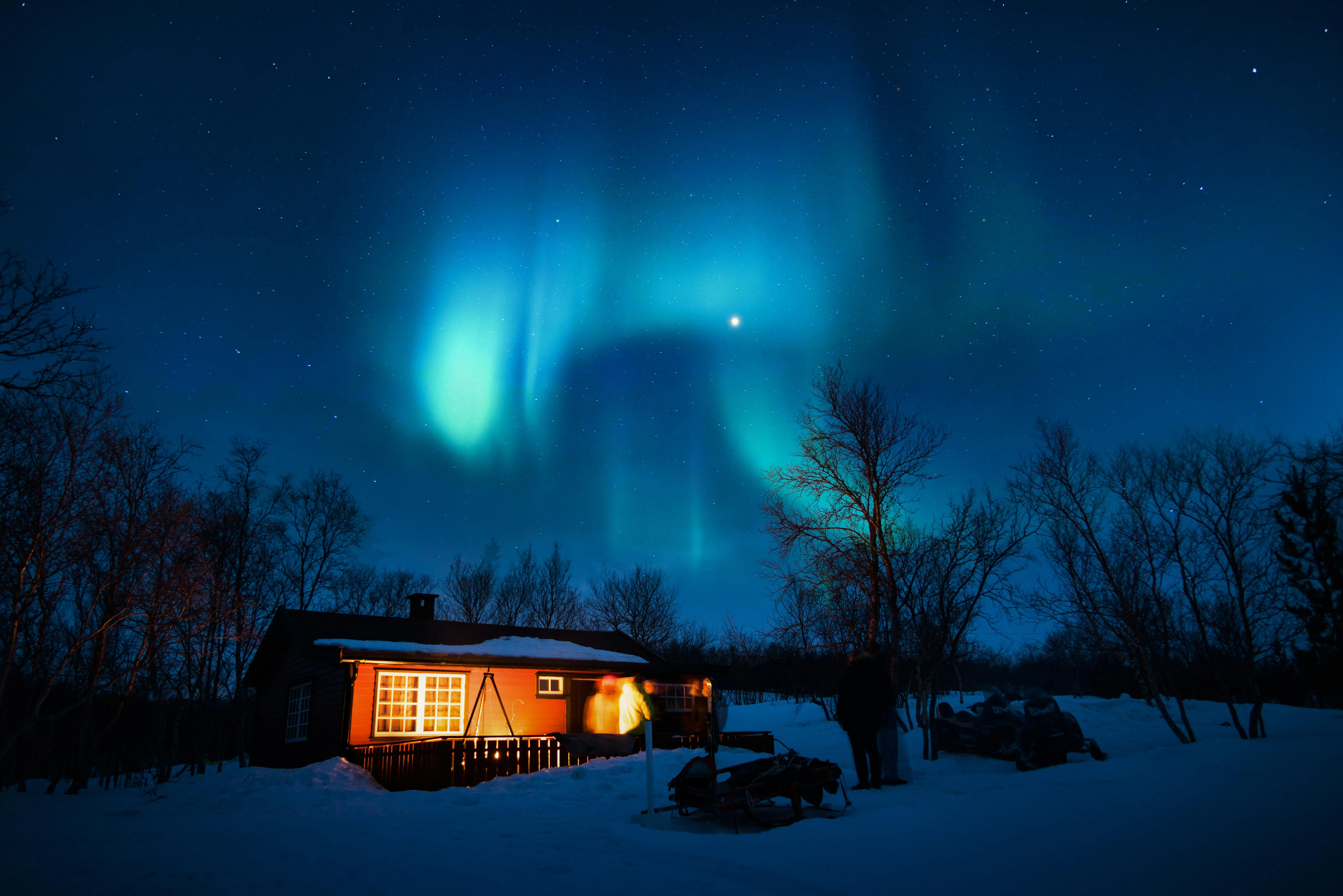 House Lit Up at Night Under Dark Sky with Northern Lights