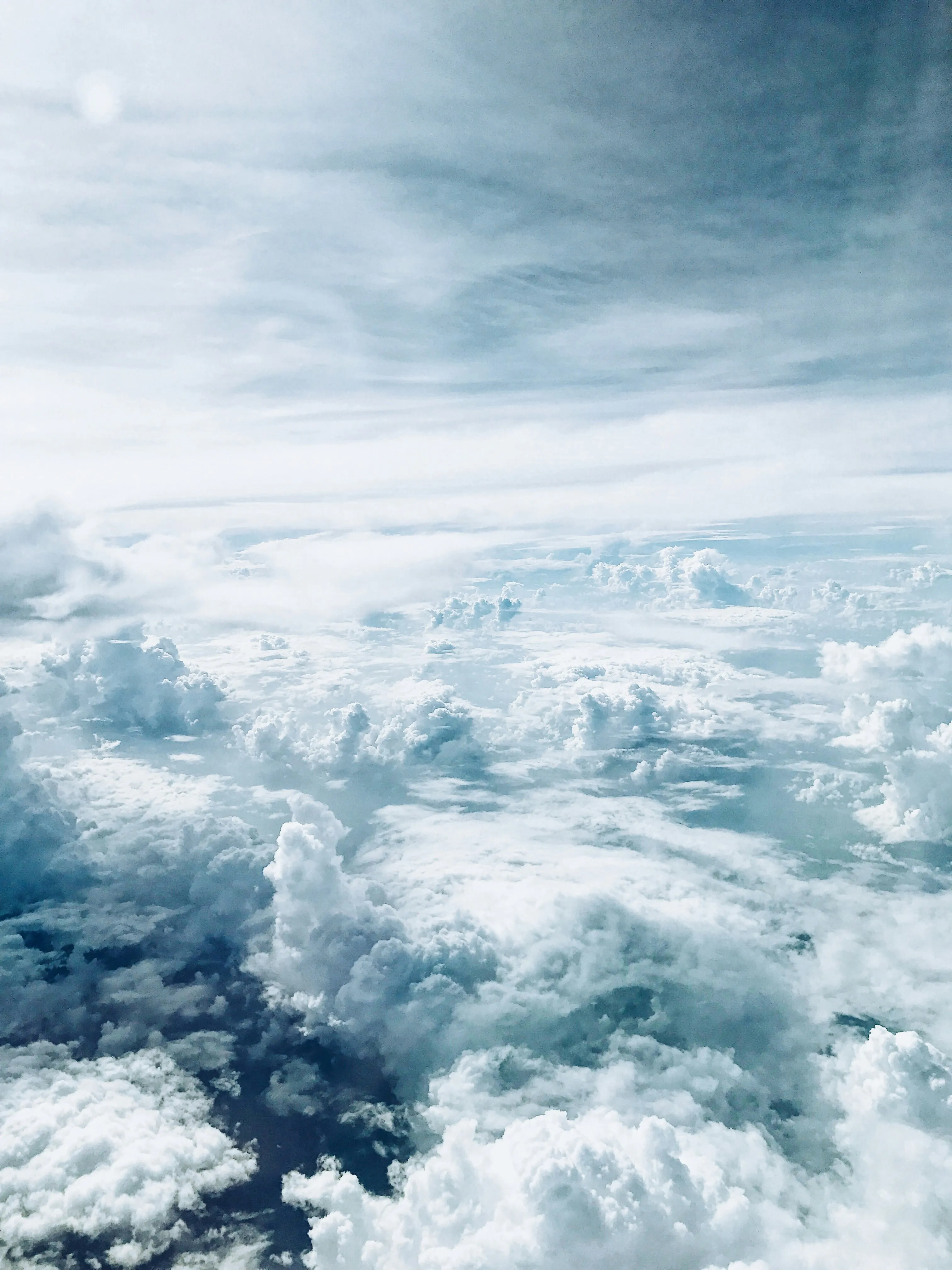 Icy Mountain Tops Covered with Thick Clouds From Airplane