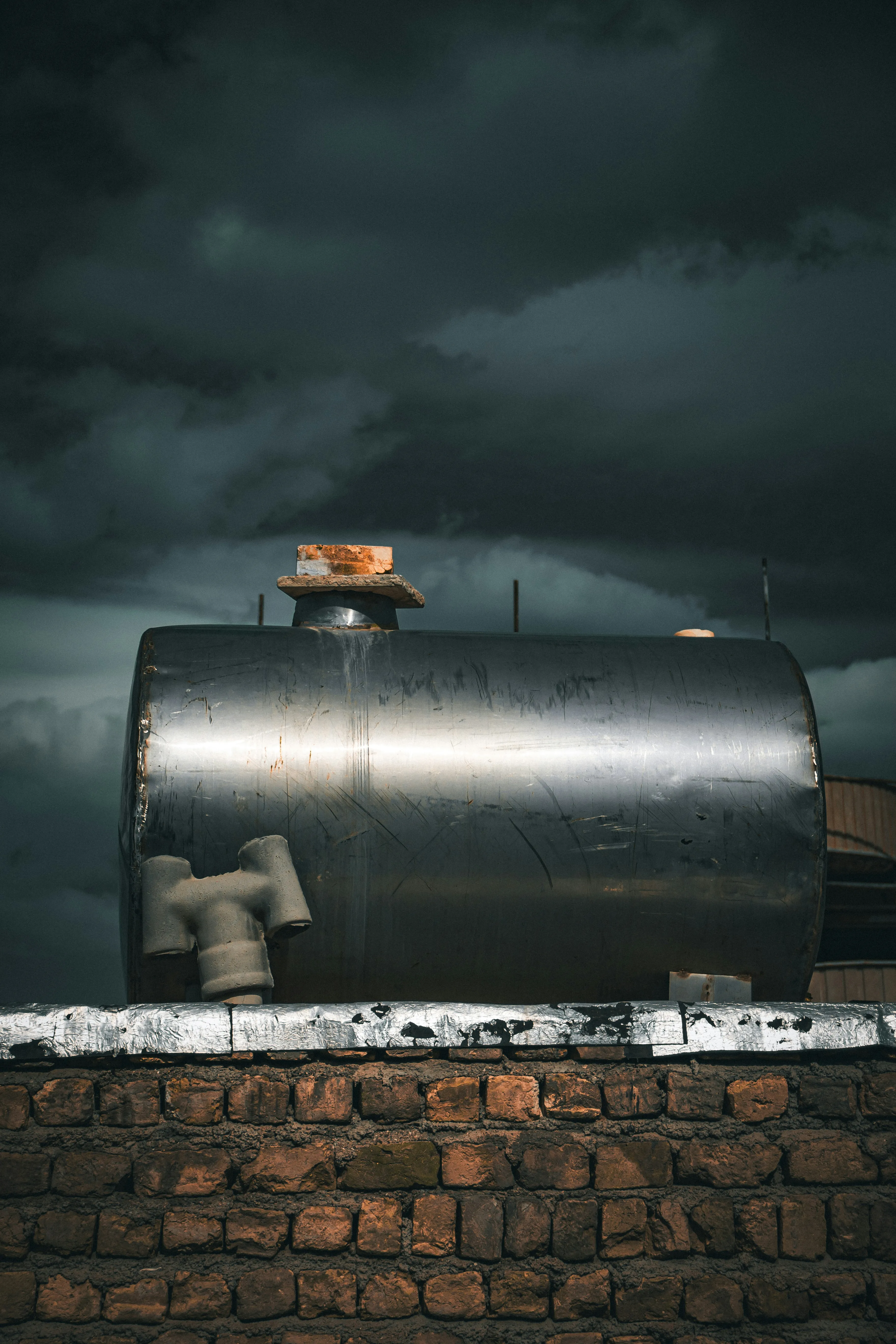 Industrial Scene with Metal Tank and Dark Stormy Sky Clouds