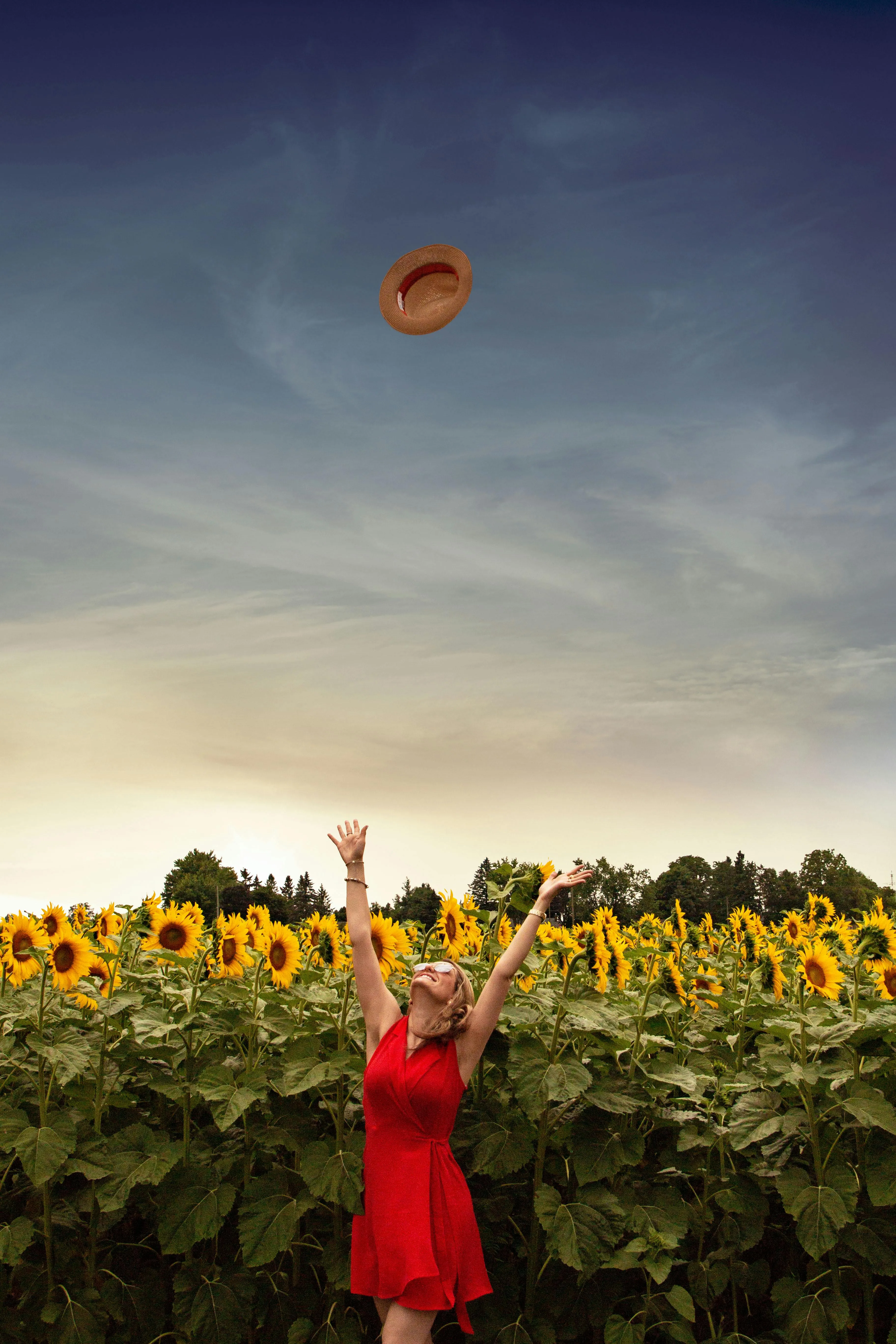 Joyful Woman in Red Dress Surrounded By Bright Sunflowers