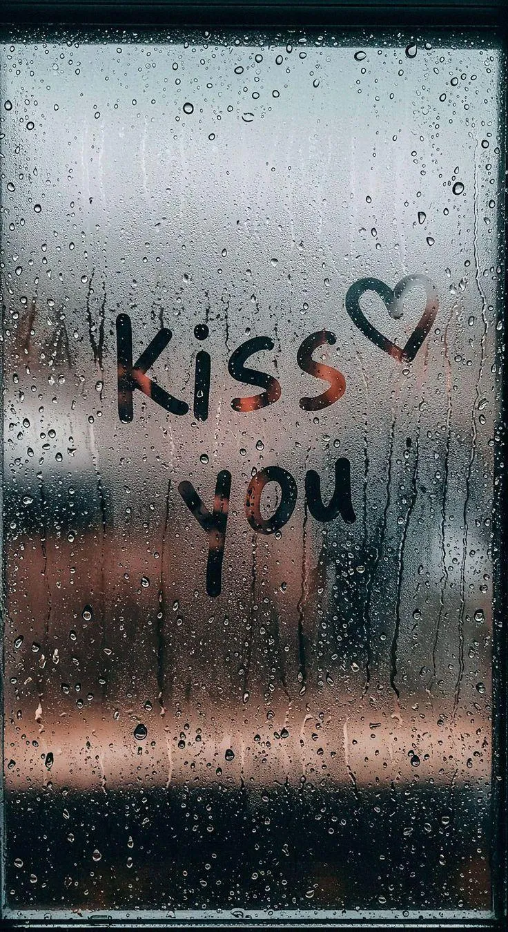 Kiss You Message Written on Fogged Rain Covered Glass