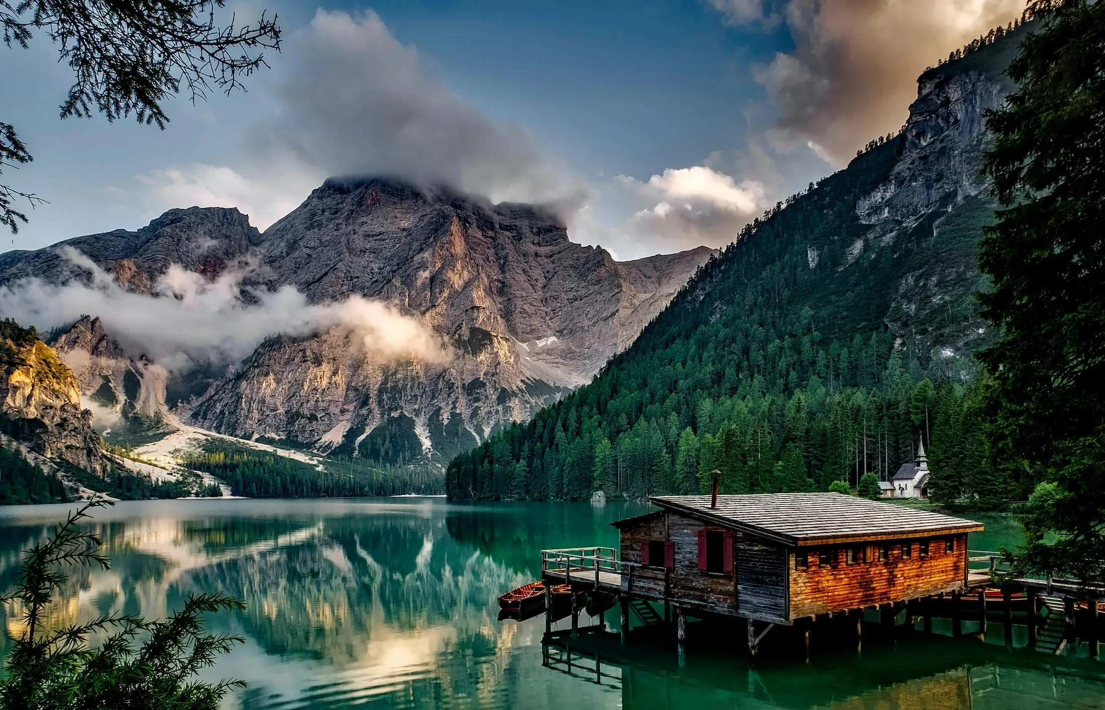 Lake and Cabin Surrounded by Mountains and Pine Forest