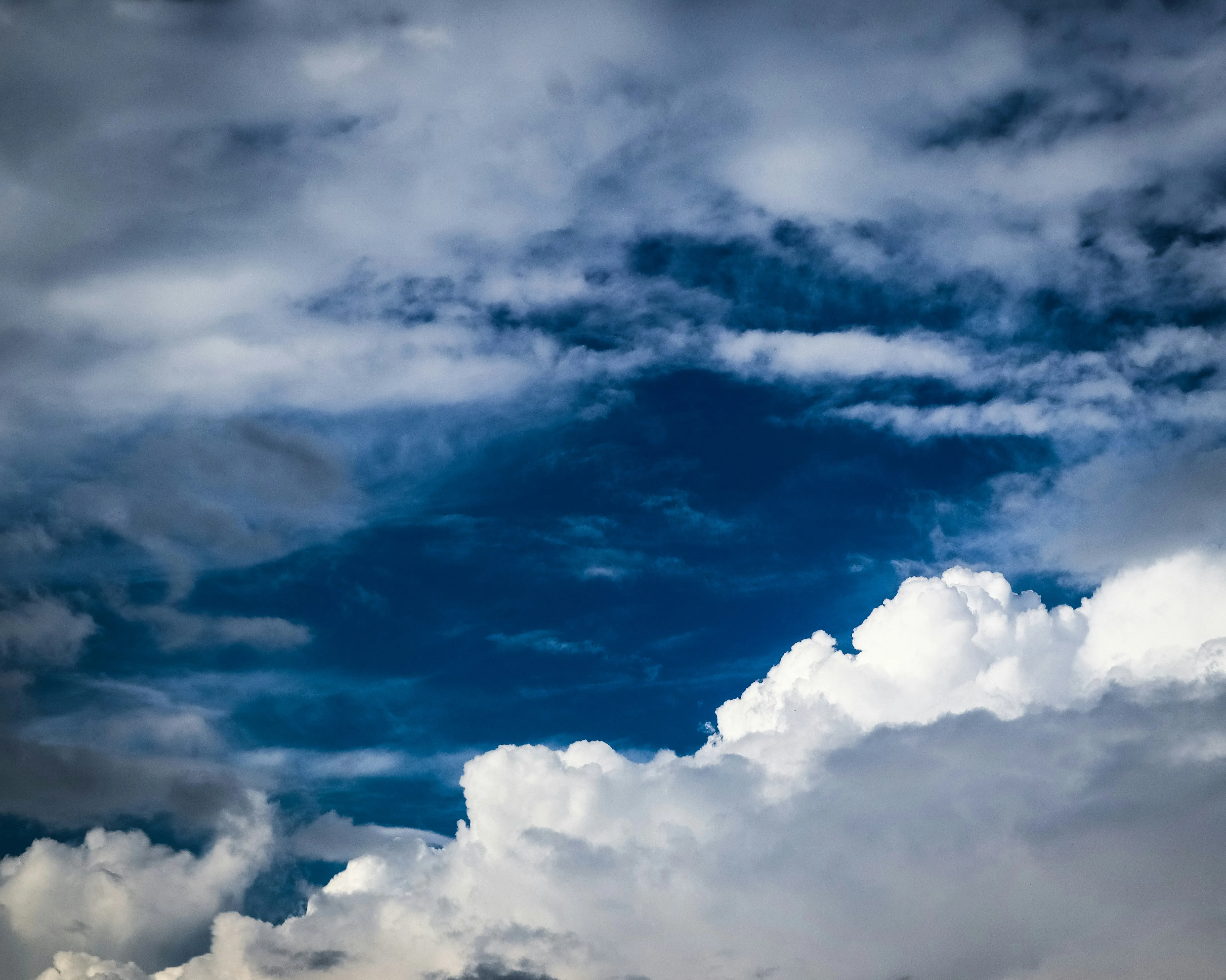 Large Puffy Clouds in Deep Blue Sky Over Landscape HD Image