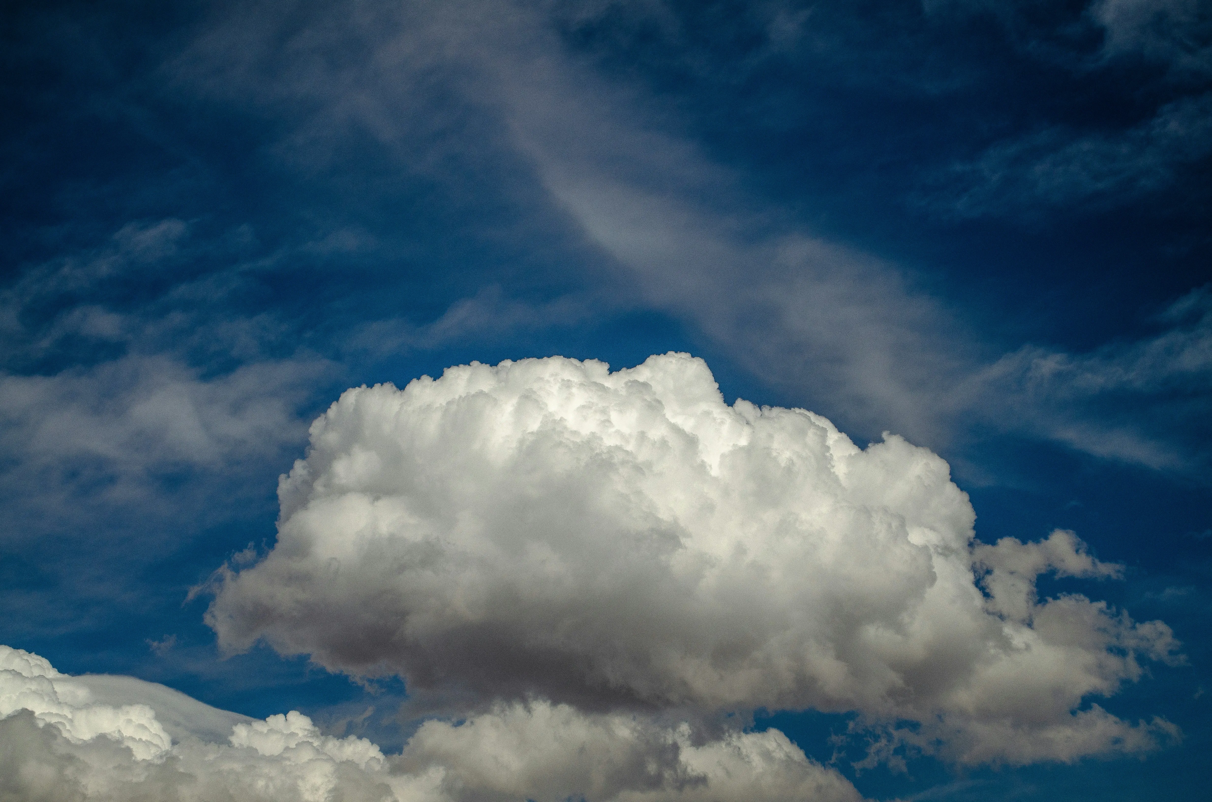 Large White Cloud Drifting Beneath a Deep Blue Sky Image