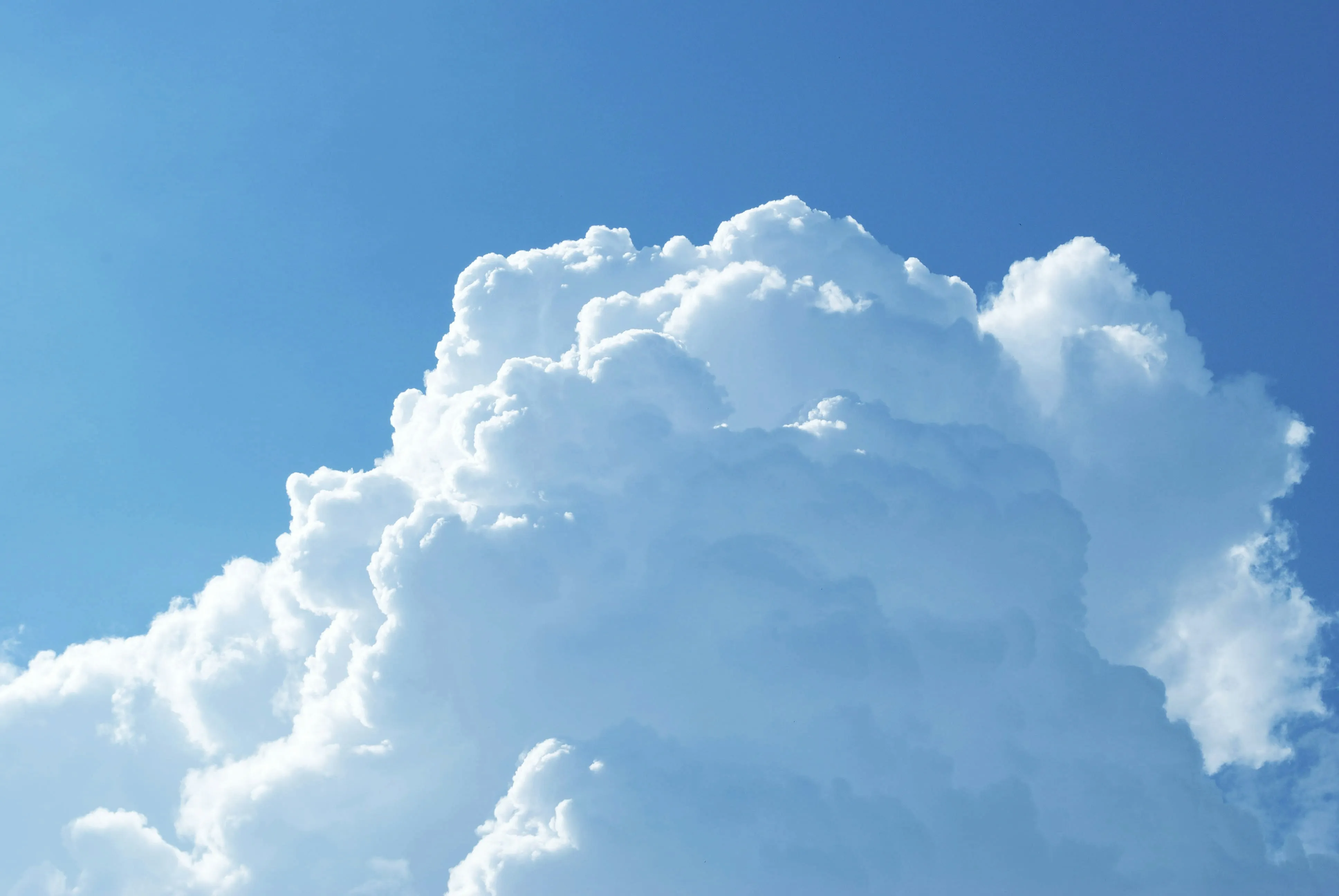 Large White Clouds Towering Into Bright Blue Skywallpaper