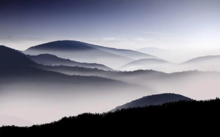 Layered Mountain Ridges Under Calm Early Morning Mist
