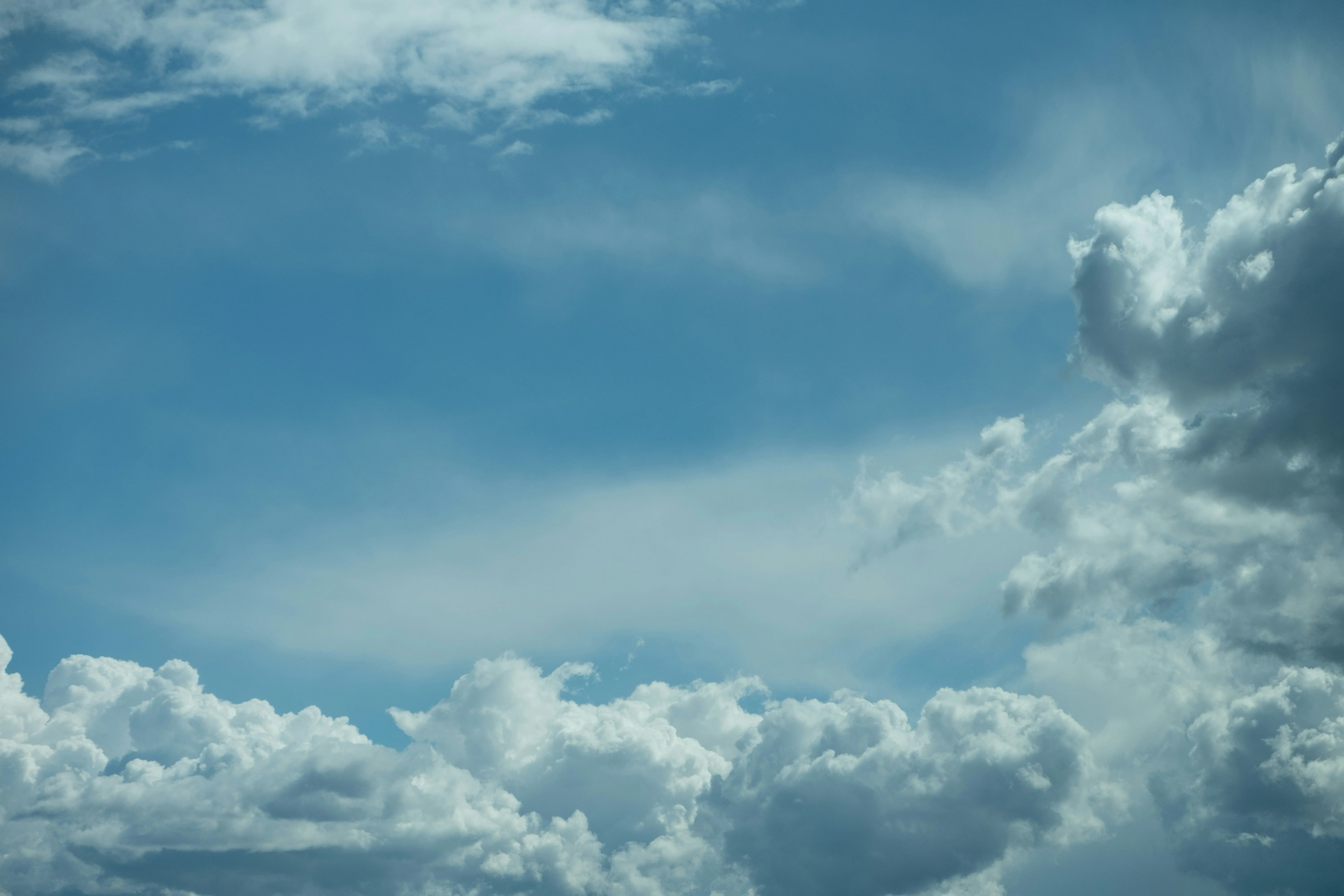 Light Blue Sky with Thick White Clouds Overhead Image