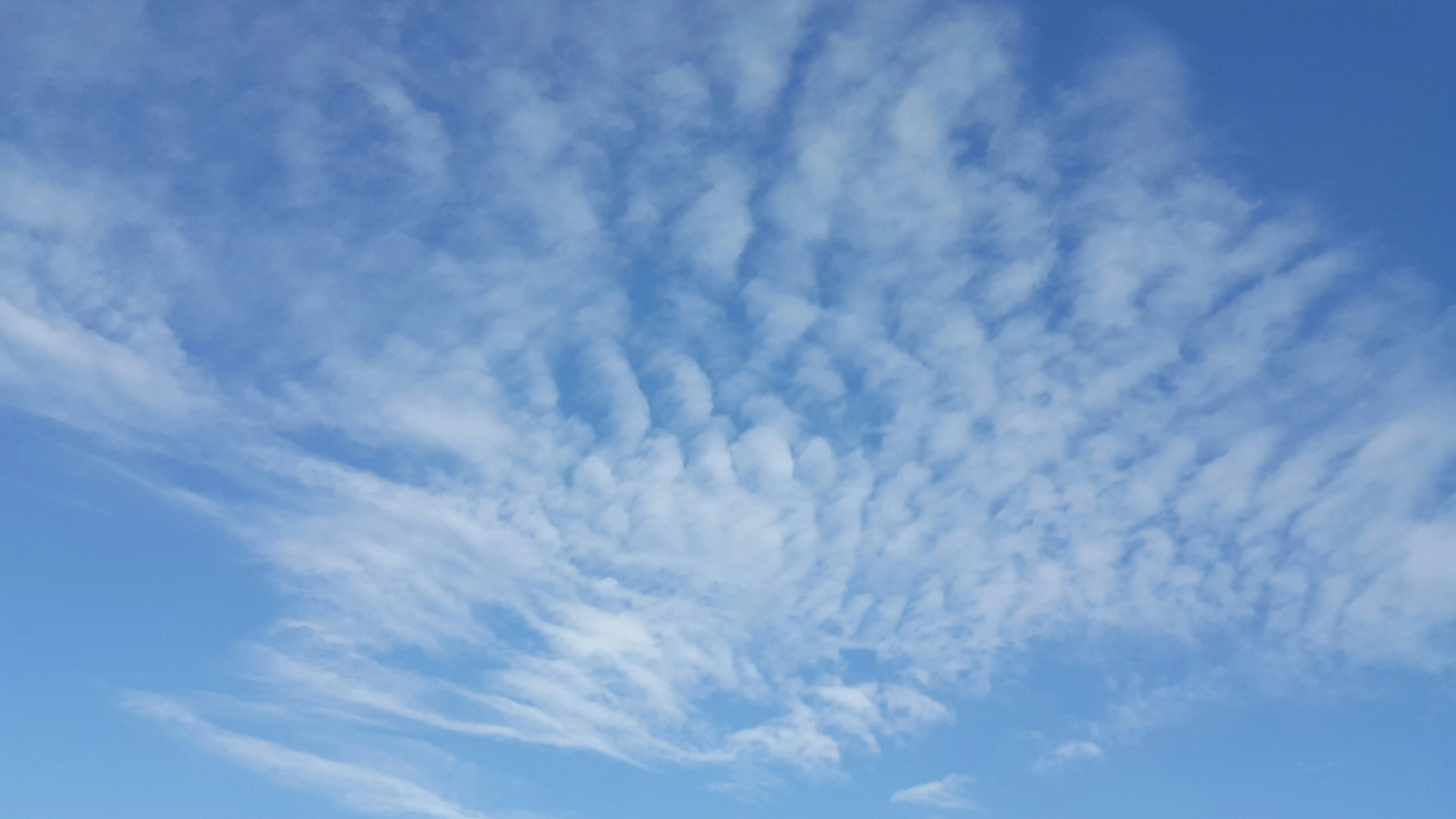 Light Cirrus Clouds Stretched Across Bright Blue Sky