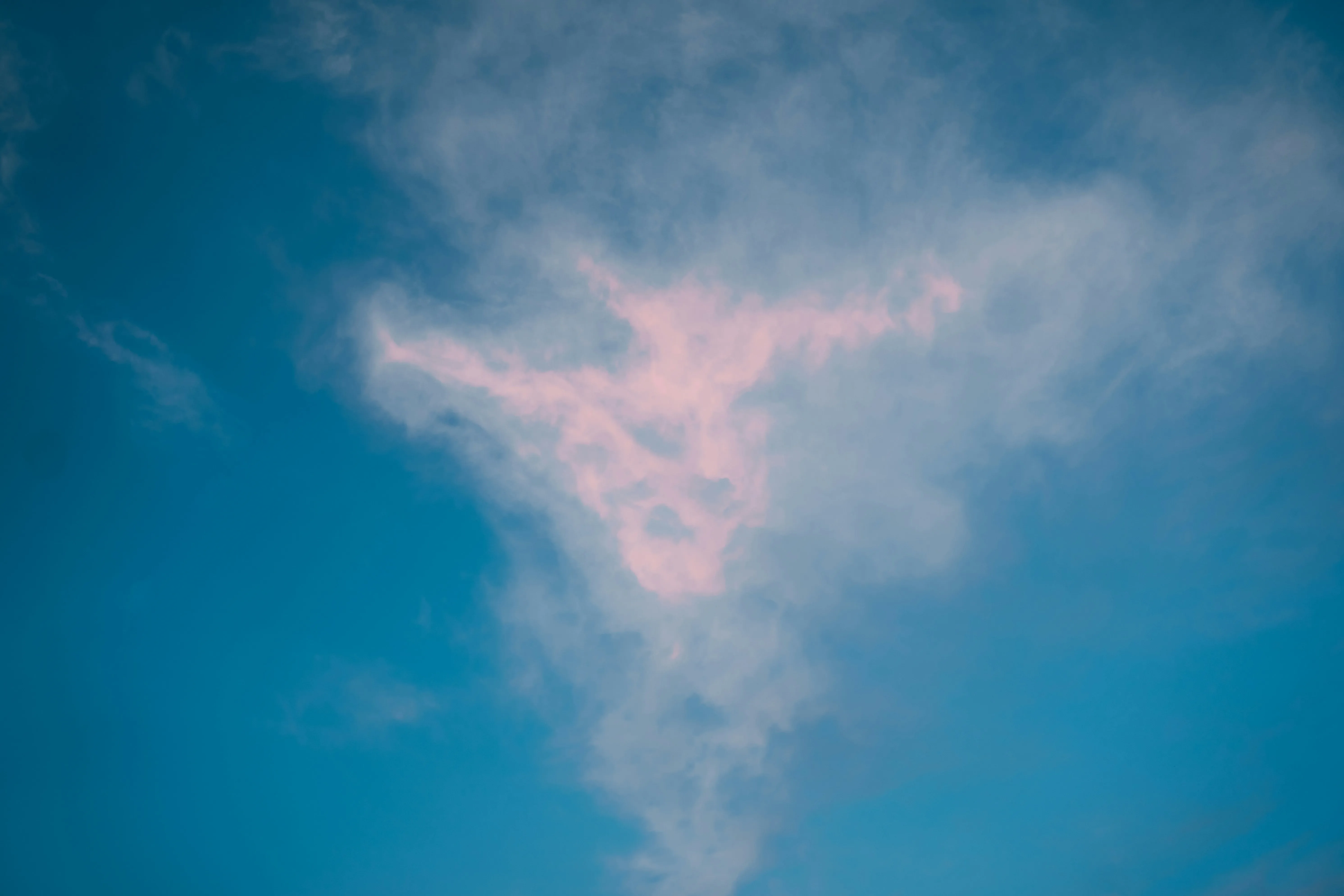 Light Pink and Blue Clouds Mixing in Clear Blue Sky