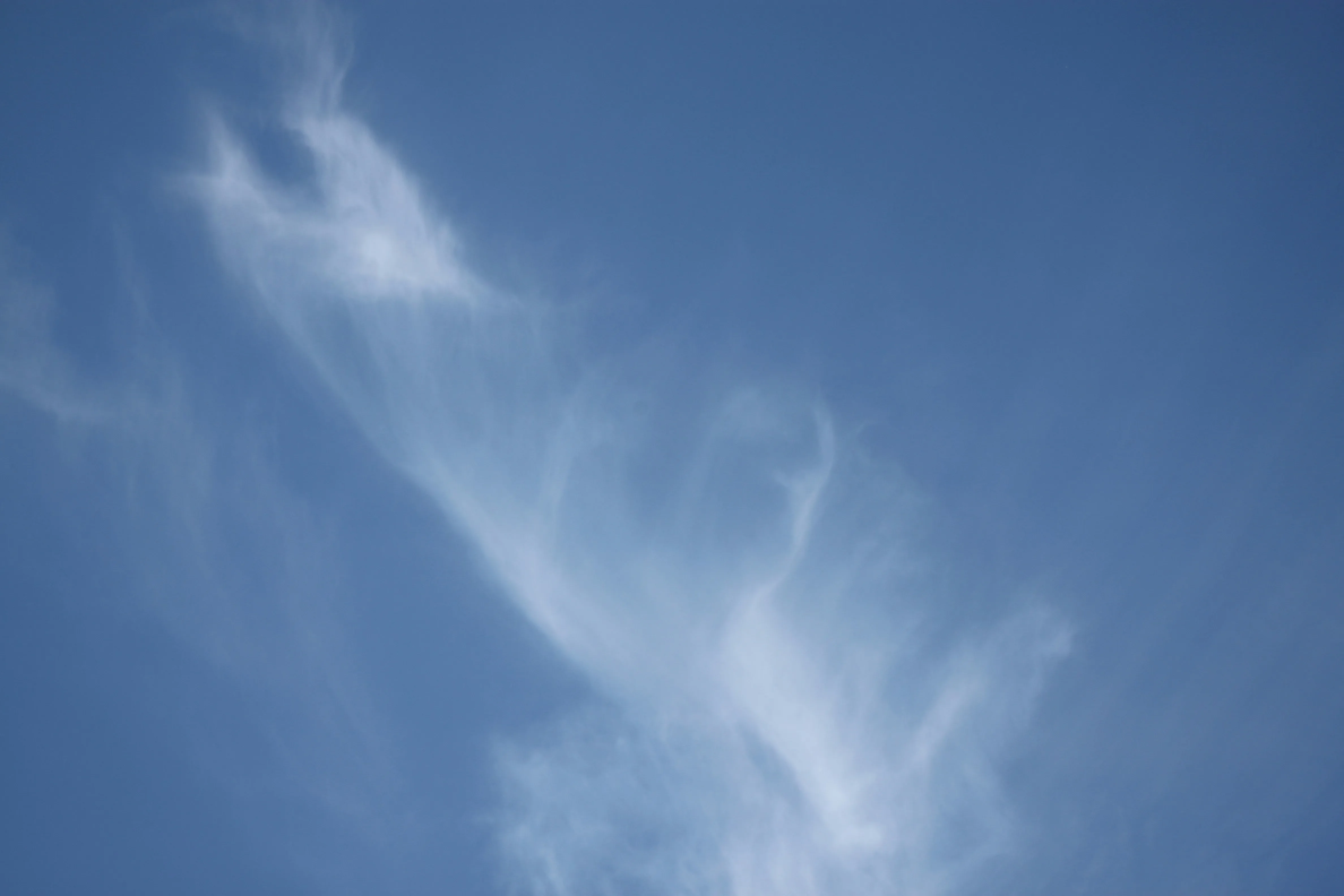Light Wispy Clouds Moving Across a Clear Blue Sky Image