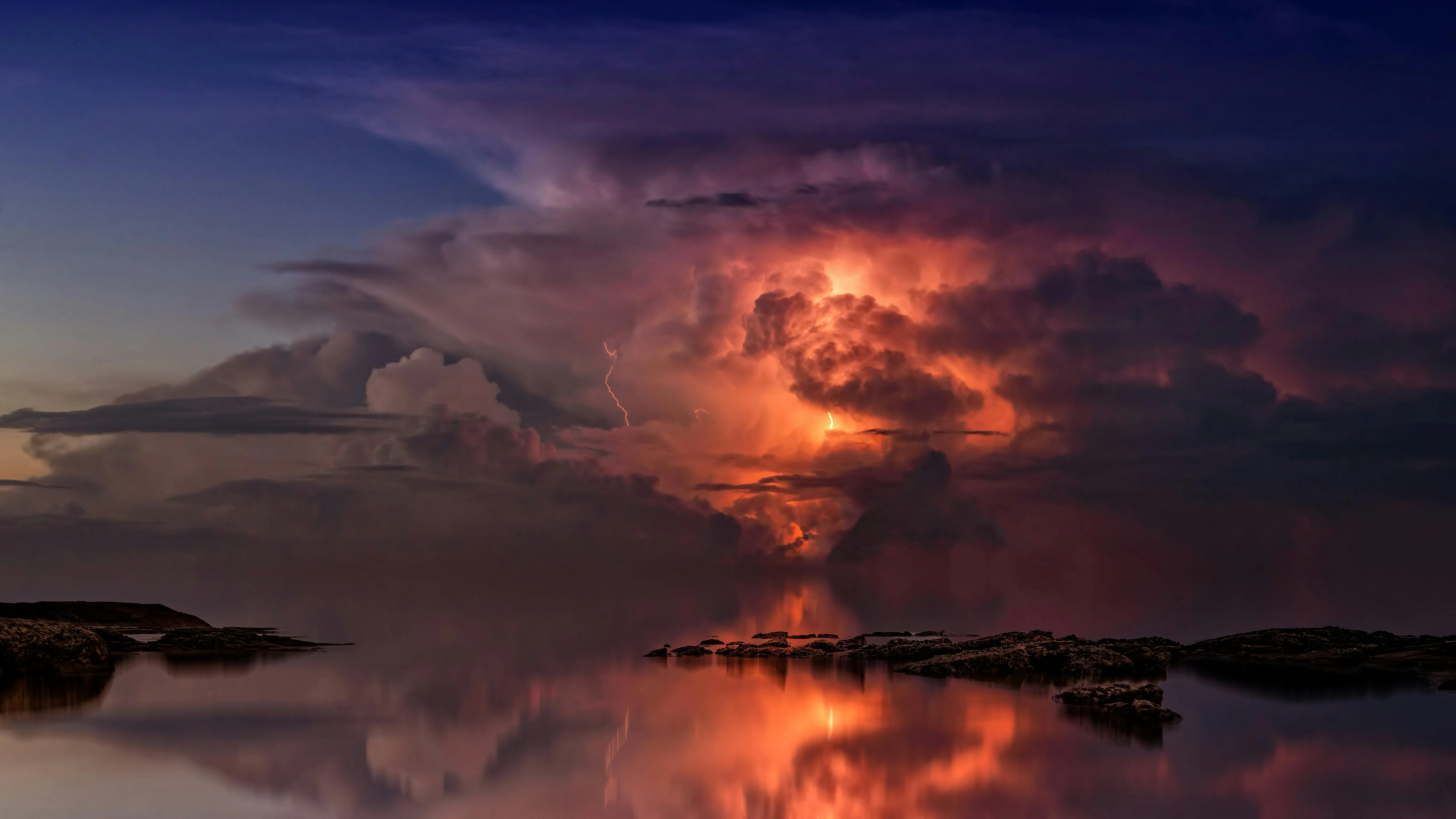 Lightning Storm Illuminating Clouds Over the Ocean Wallpaper