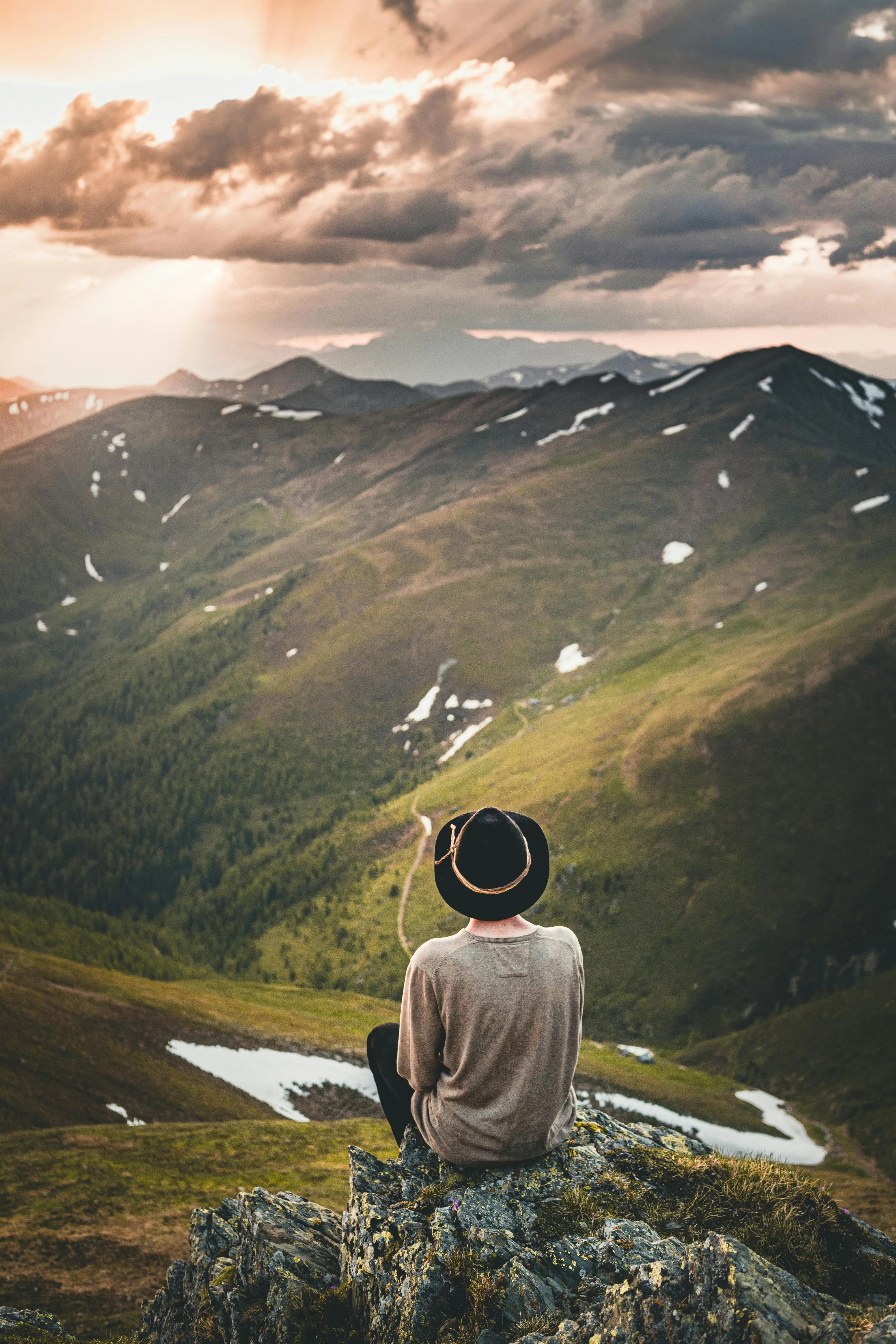 Lone Traveler Facing Mountain View with Sunset Skies
