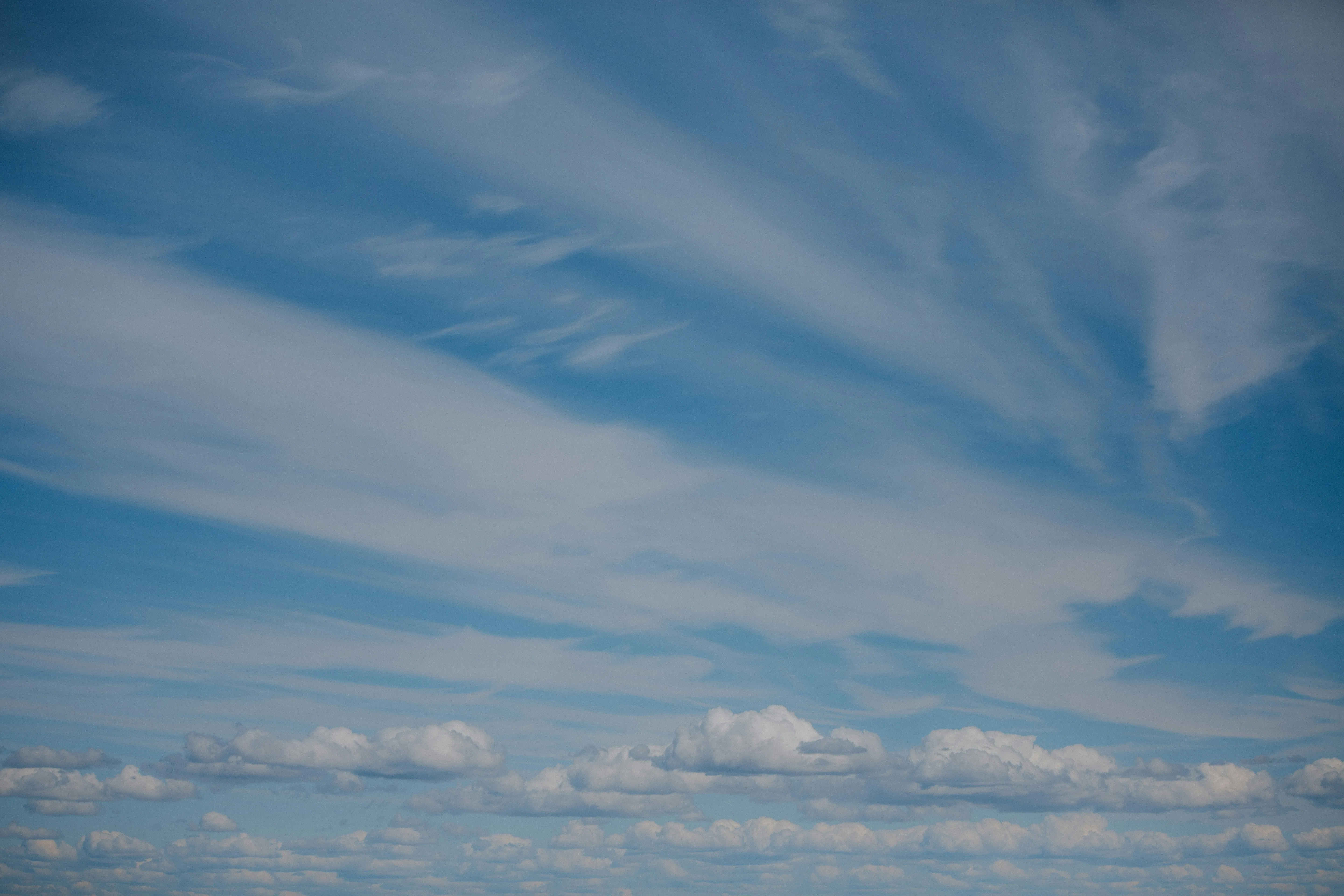 Long Cloud Trails Across a Peaceful Ocean Horizon Wallpaper