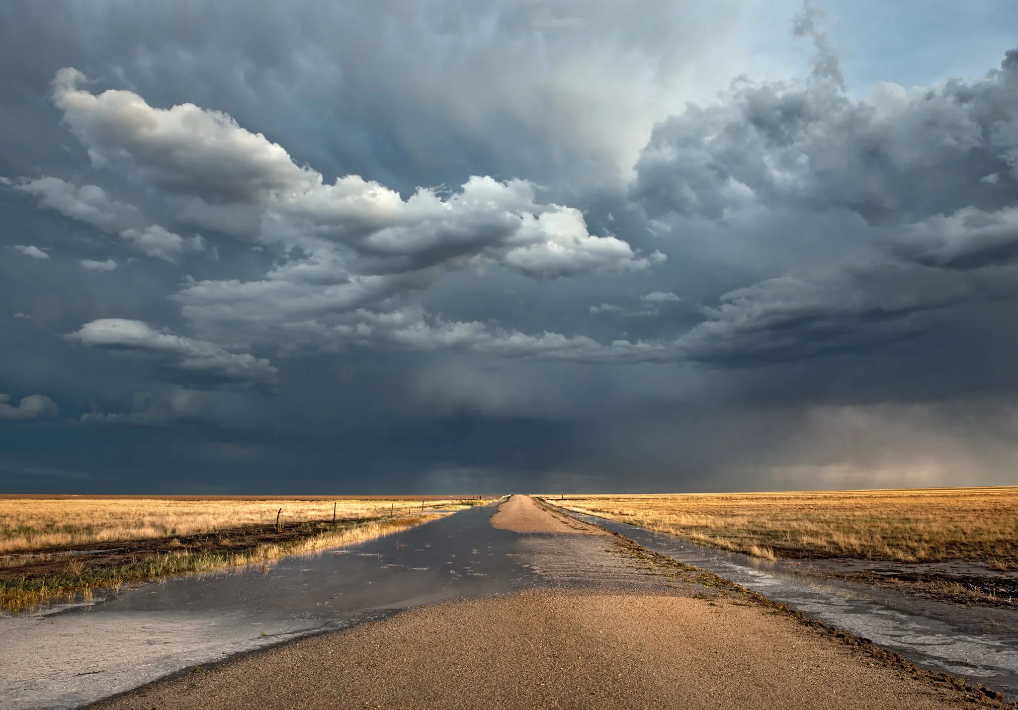 Long Empty Road Stretching Through Dry Grasslands and Sky