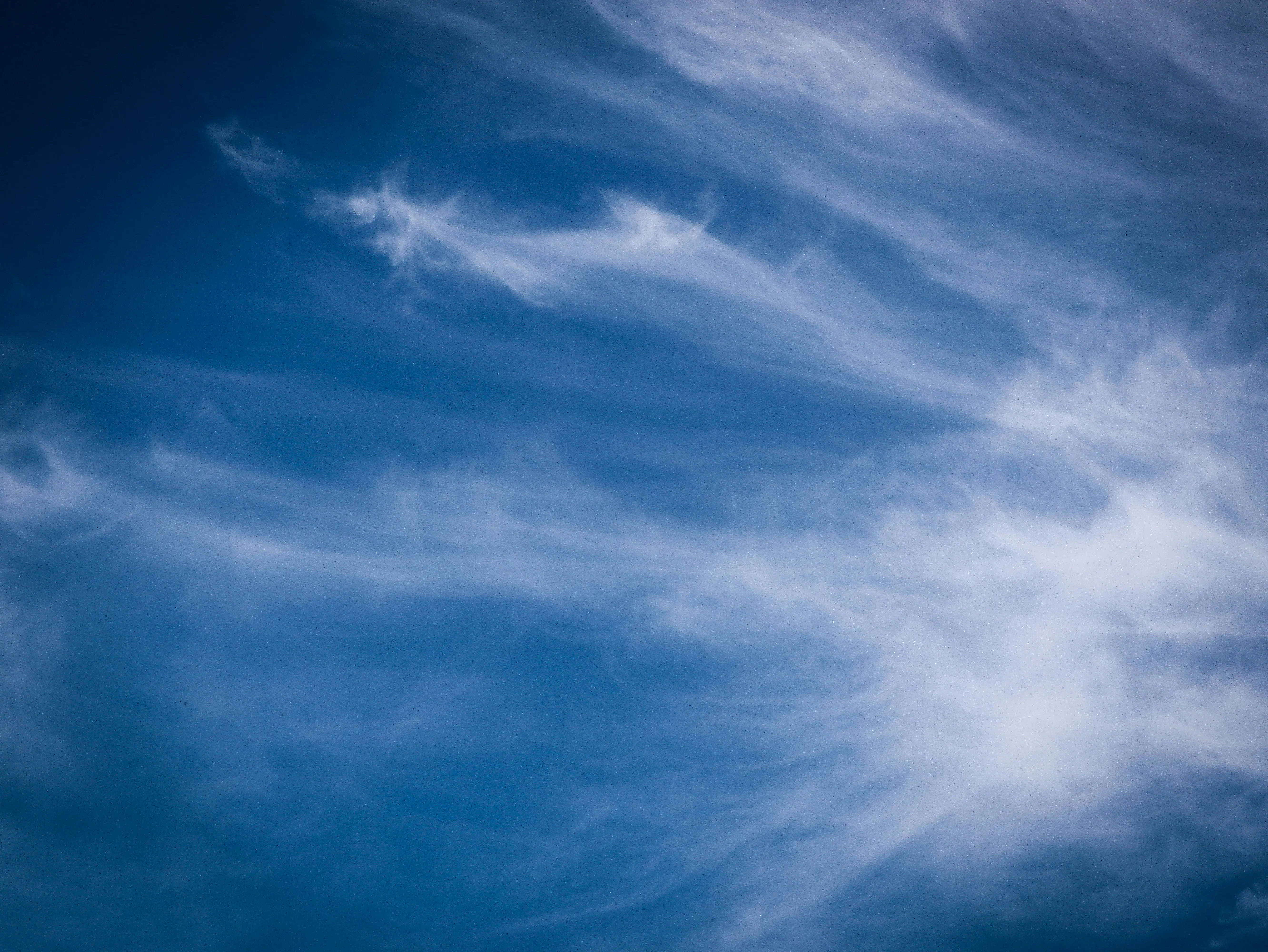 Long Wispy Cirrus Clouds Stretching Across Blue Sky