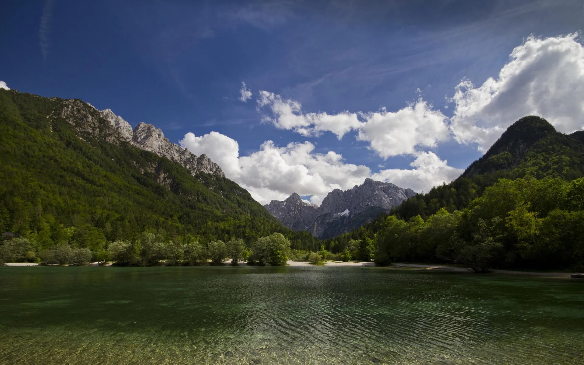 Lush Green Field Framed by Rolling Mountain Ranges
