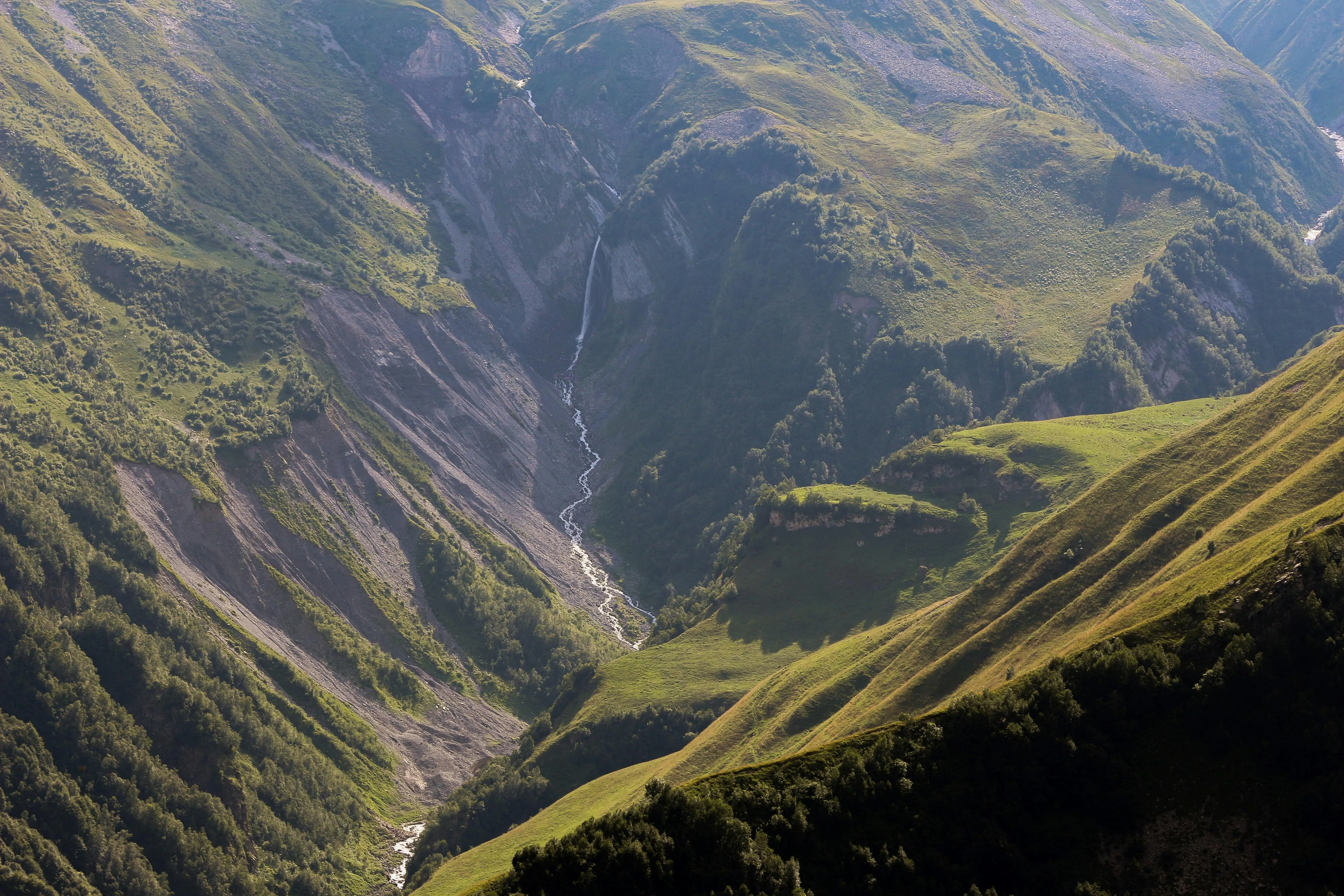 Lush green valley between dramatic mountain cliffs
