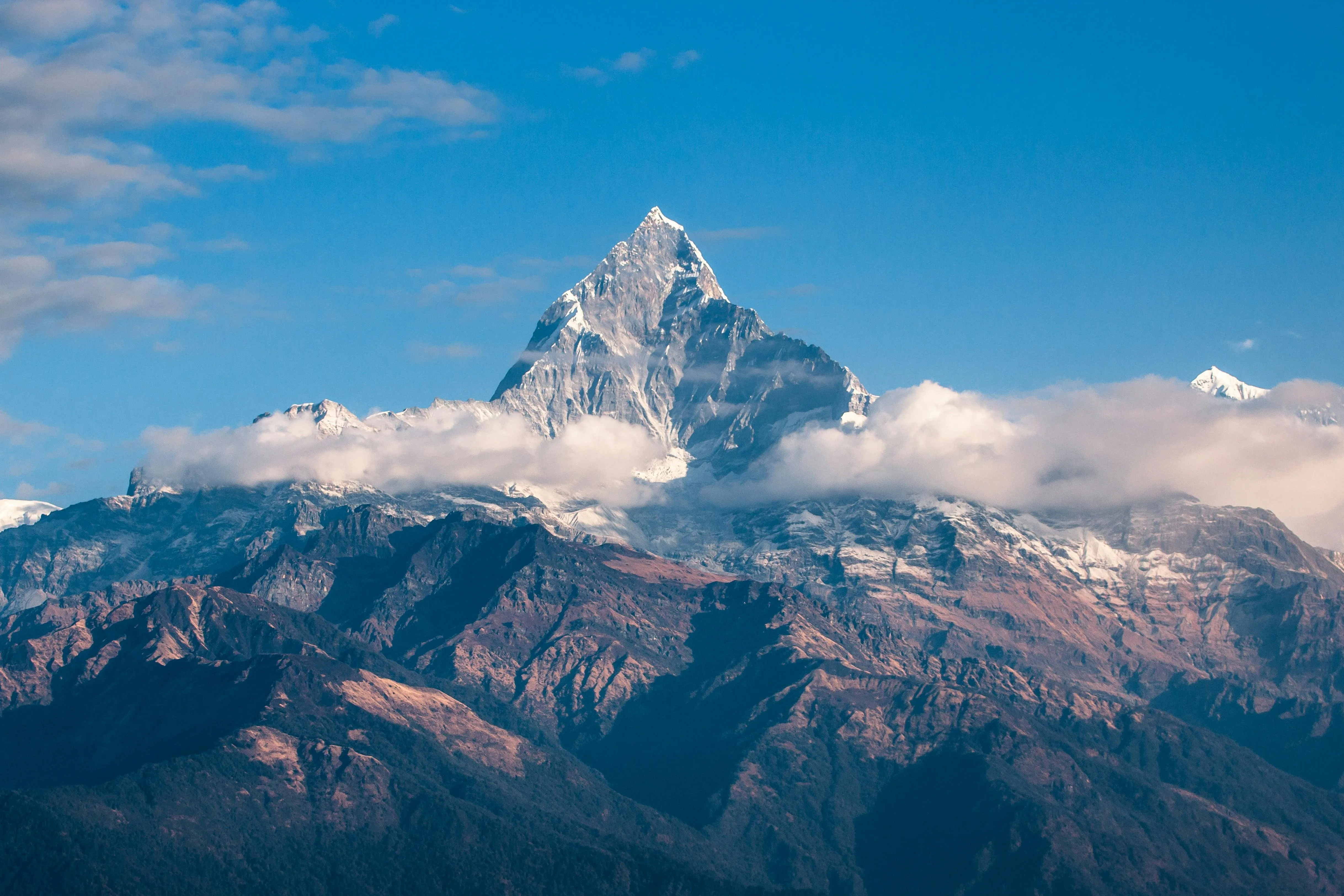 Majestic Mountain Peak Under Crisp Sky and Wispy Clouds