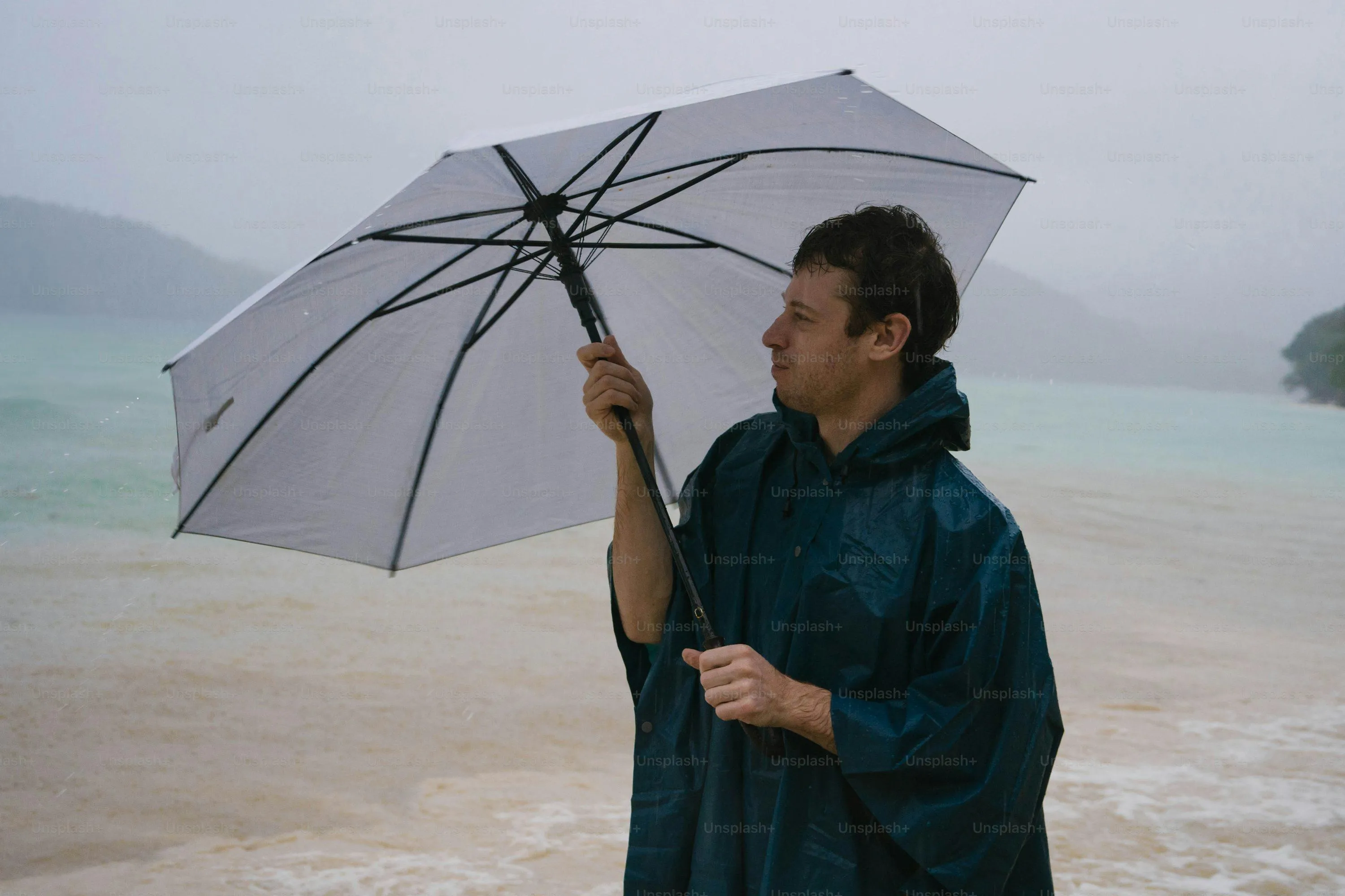 Man Holding Transparent Umbrella Standing Outdoors in Rain