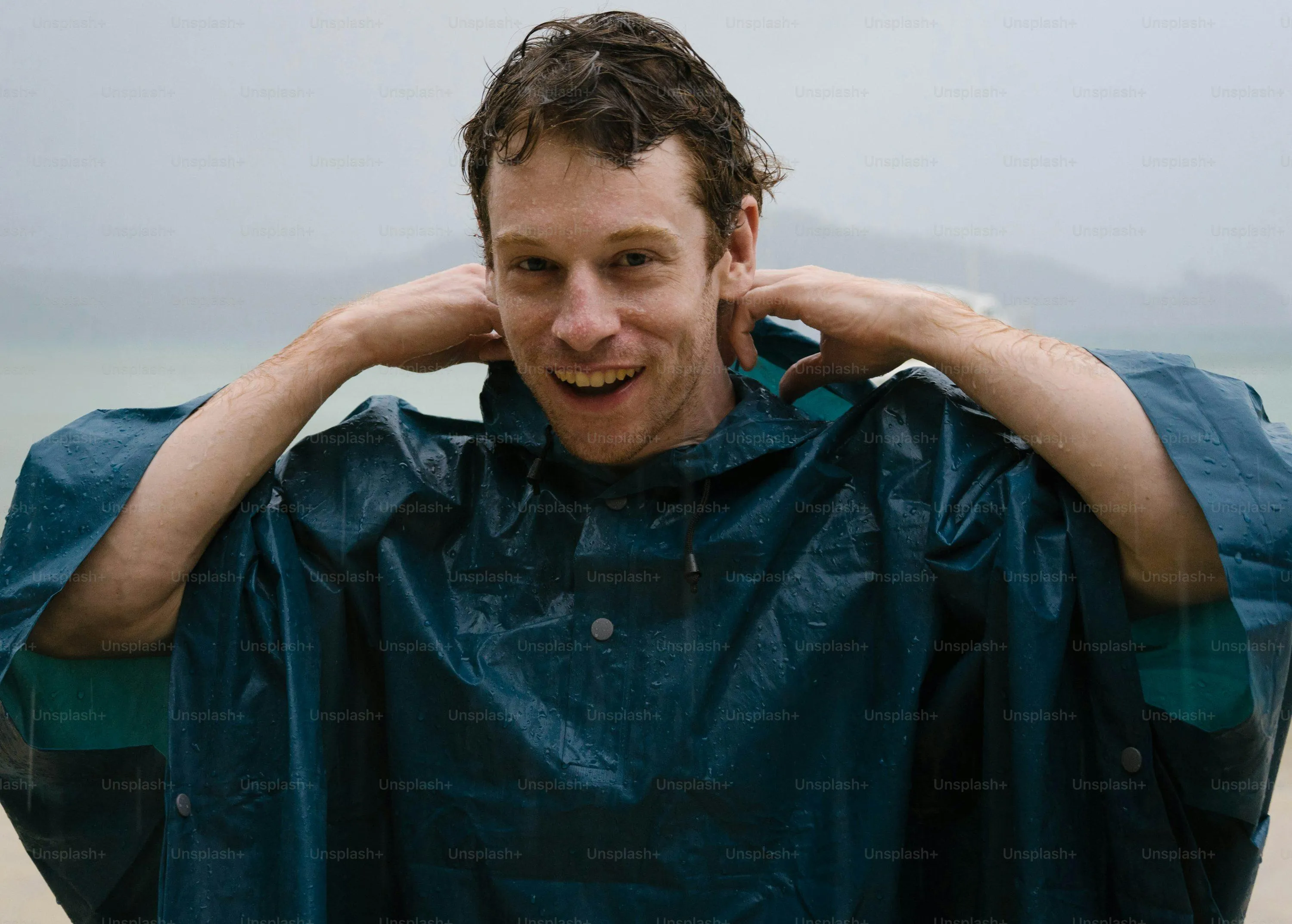 Man Smiling with Hands Near Head Wearing Blue Plaid Shirt
