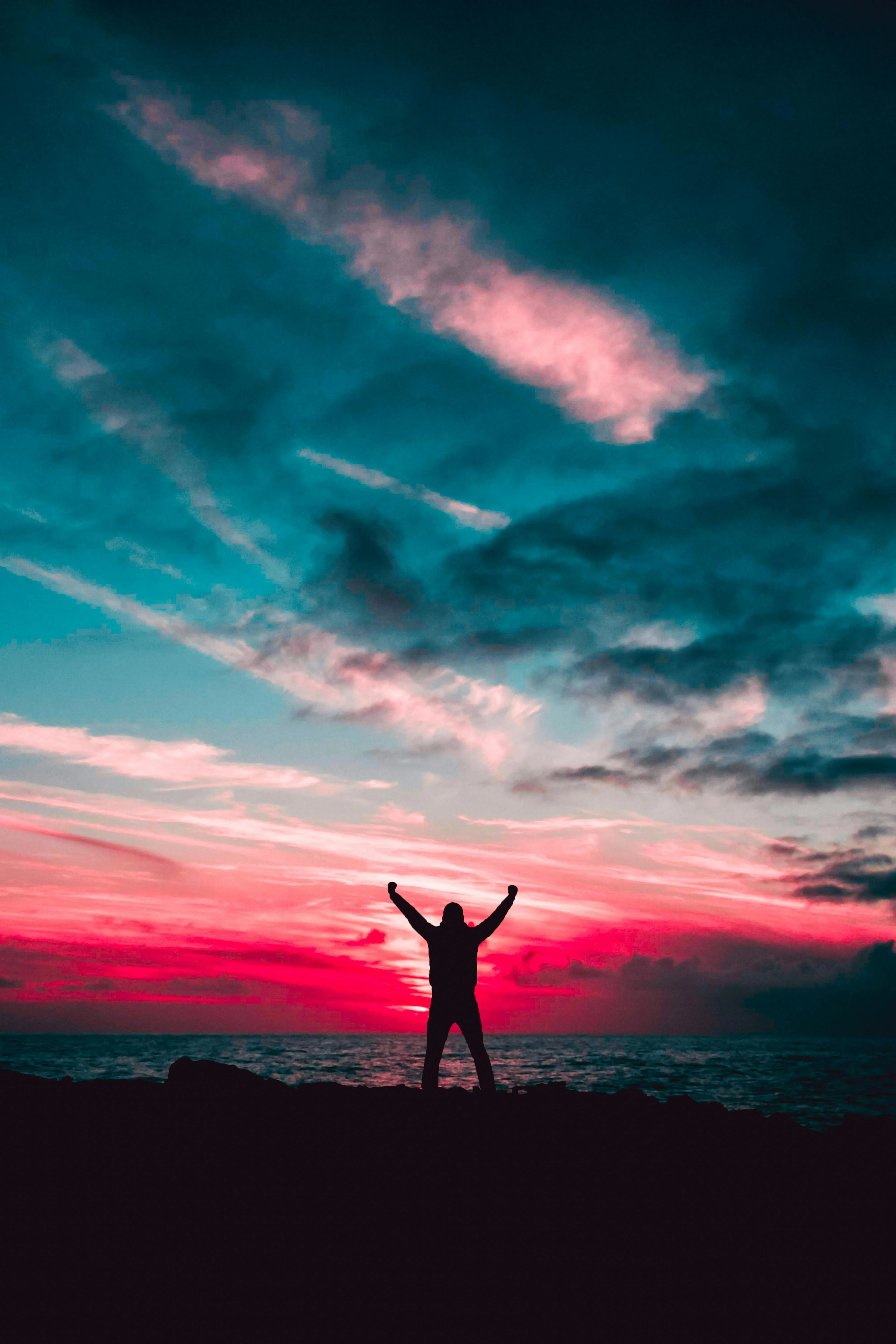 Man Standing Under Vibrant Pink and Blue Sunset Sky Image