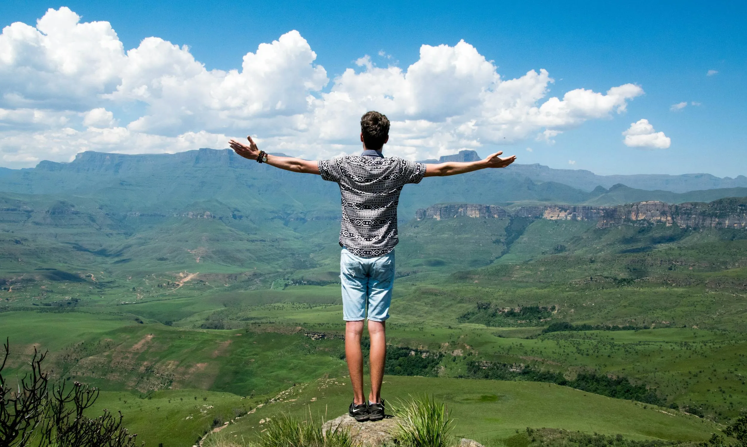 Man Standing with Arms Wide Open Enjoying Mountain View