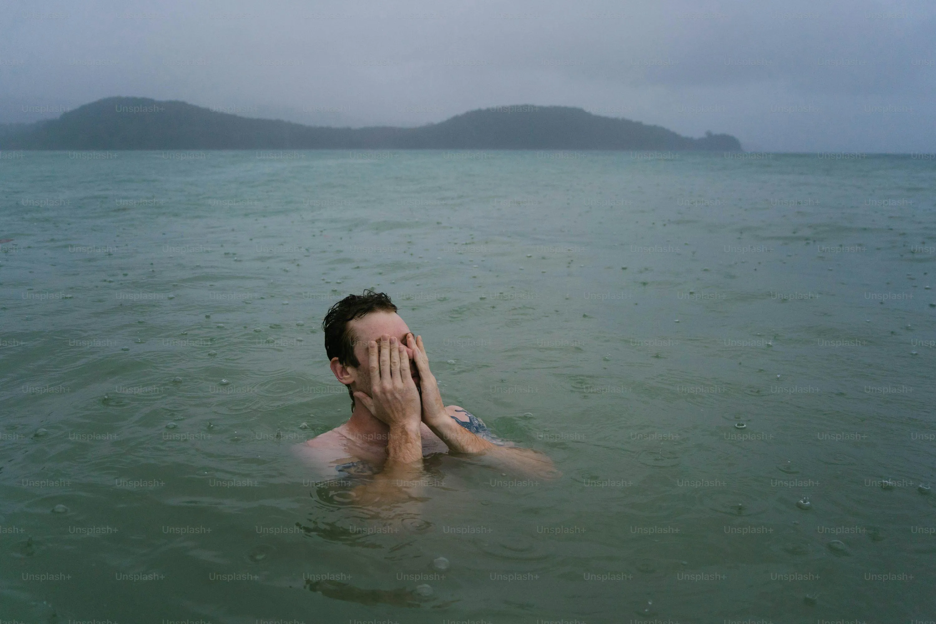 Man Swimming Calmly in Sea Under Cloudy Sky and Rain