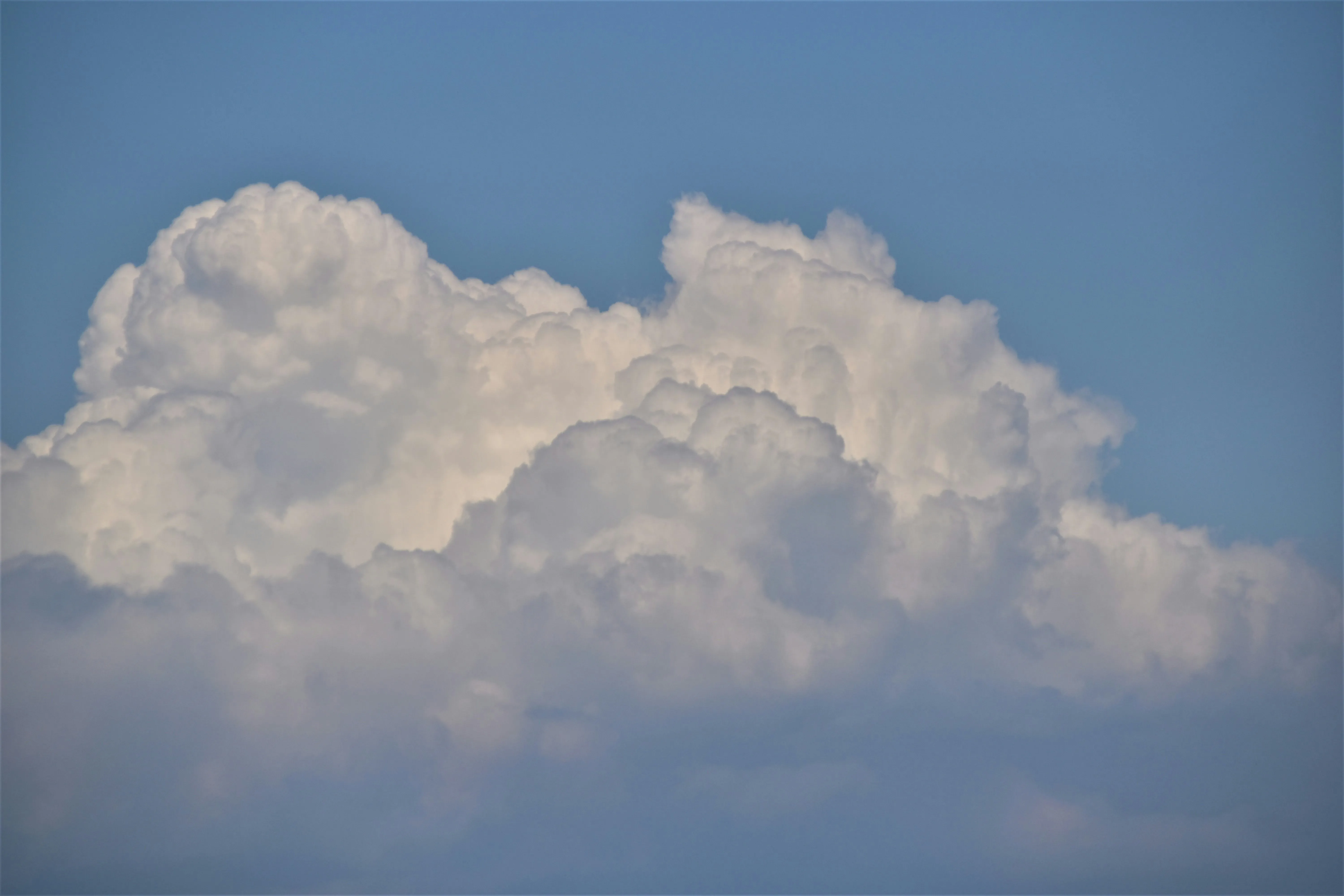 Massive Cumulus Clouds Floating Against a Blue Sky Image