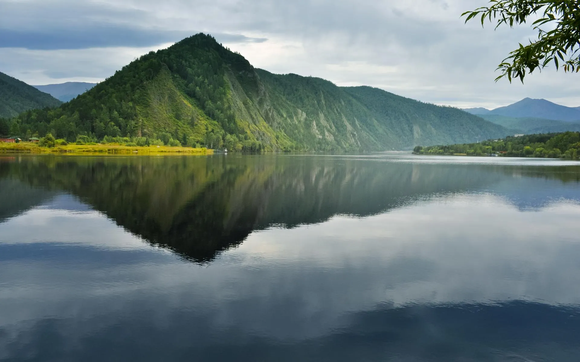Misty mountain reflected perfectly in calm lake water