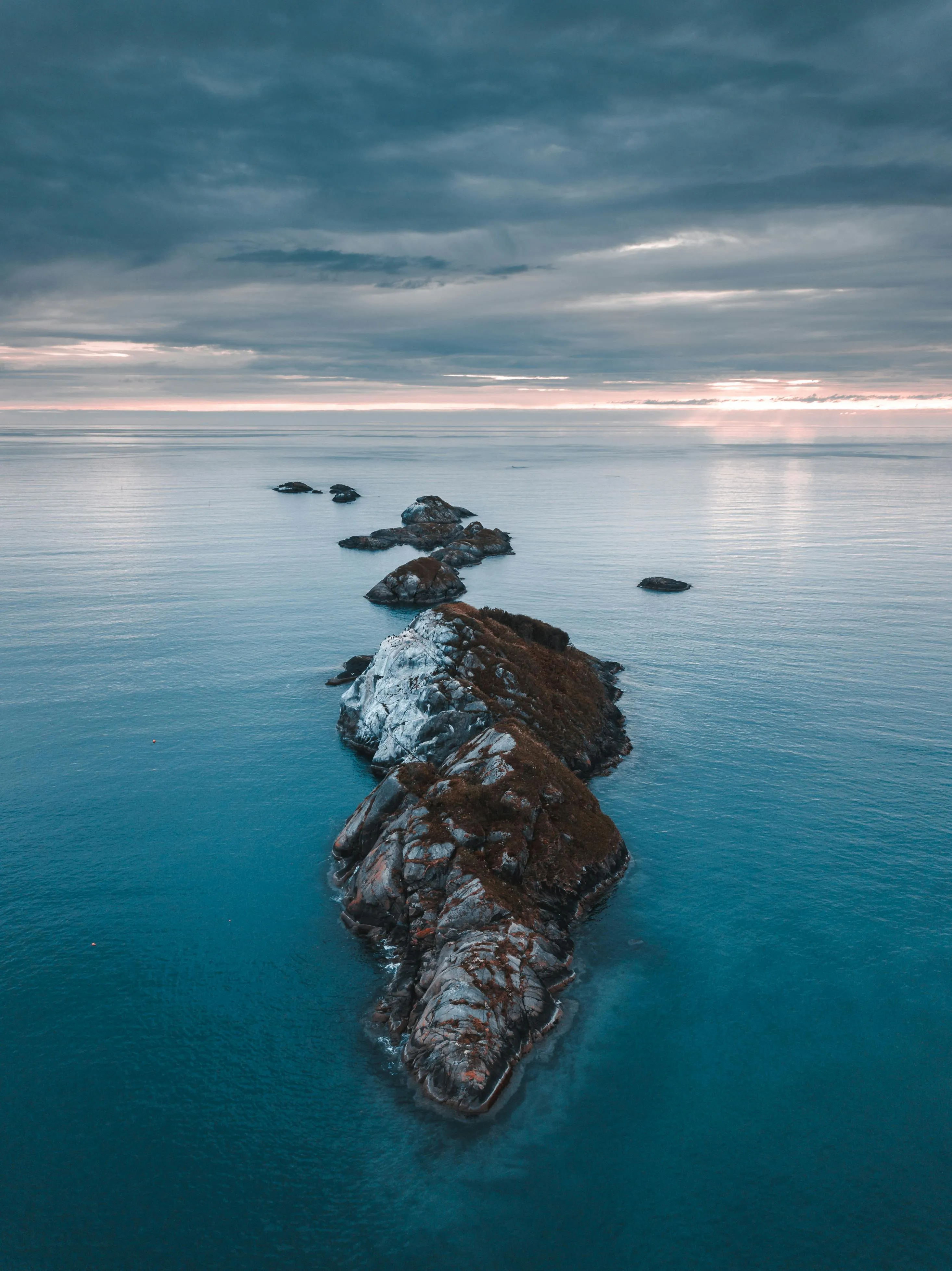 Misty Ocean Landscape with Rocky Island and Overcast Sky