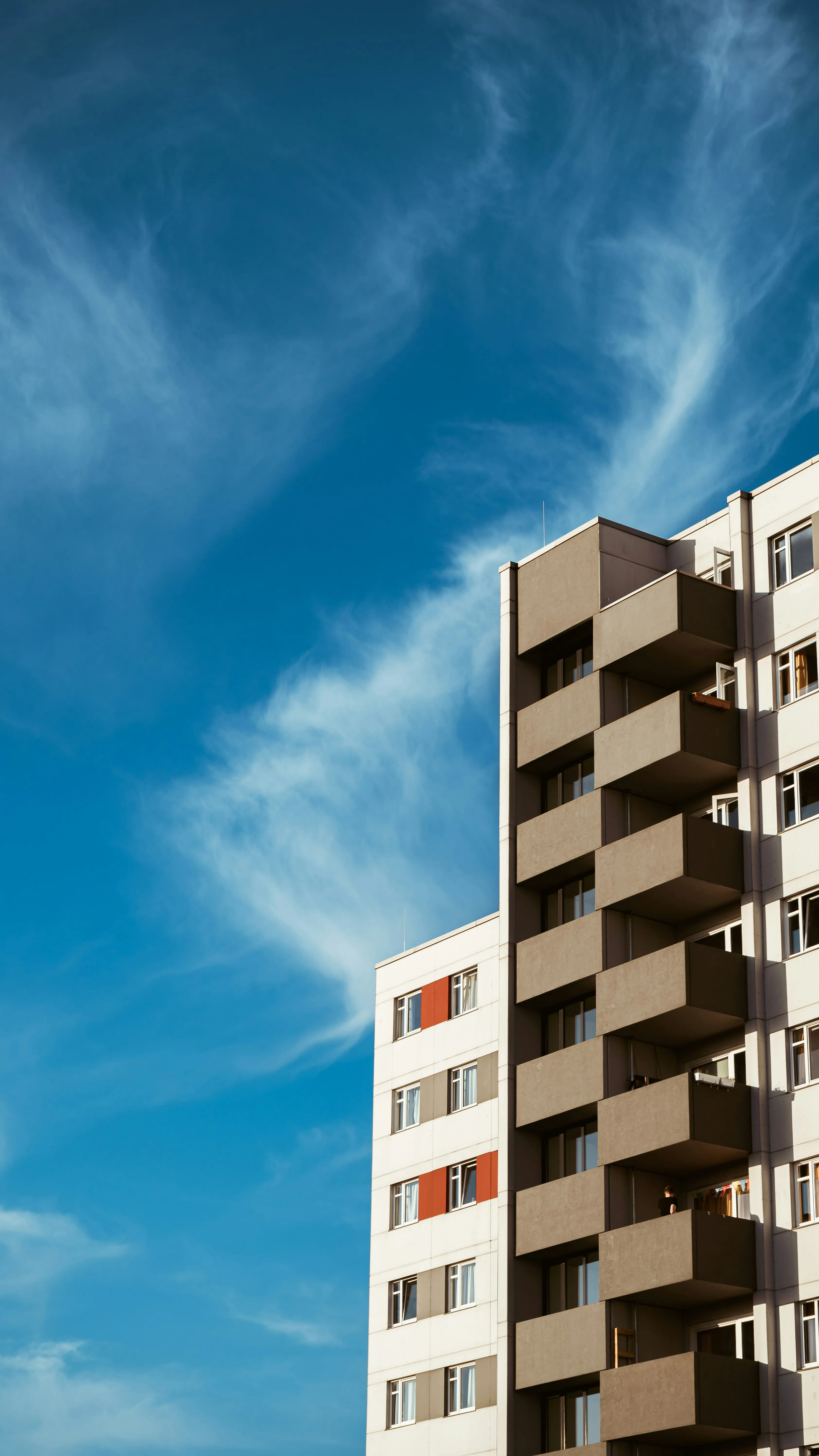 Modern Building Against Blue Sky with Soft White Clouds
