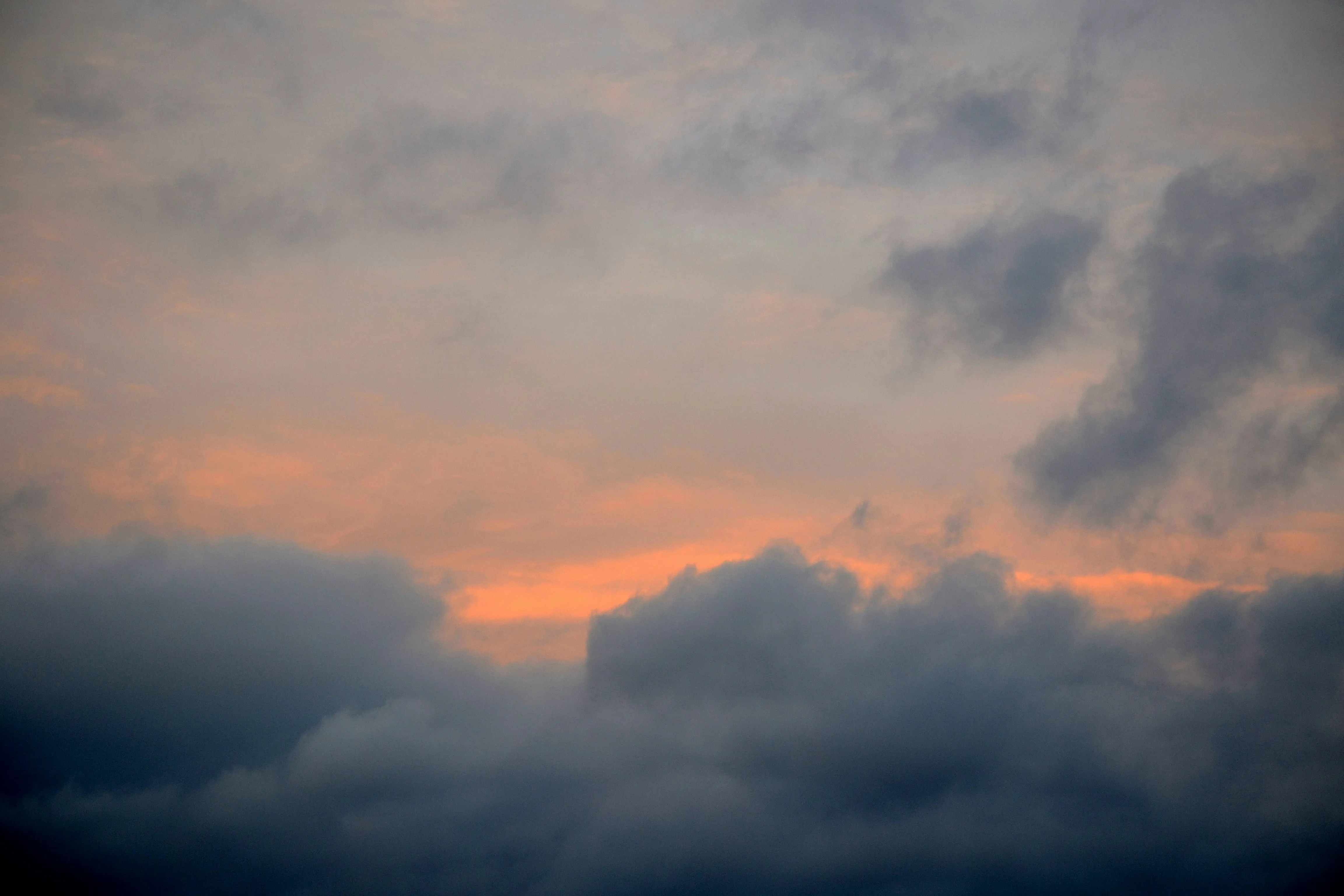 Moody Sunset Sky with Dark Clouds and Orange Hues Wallpaper