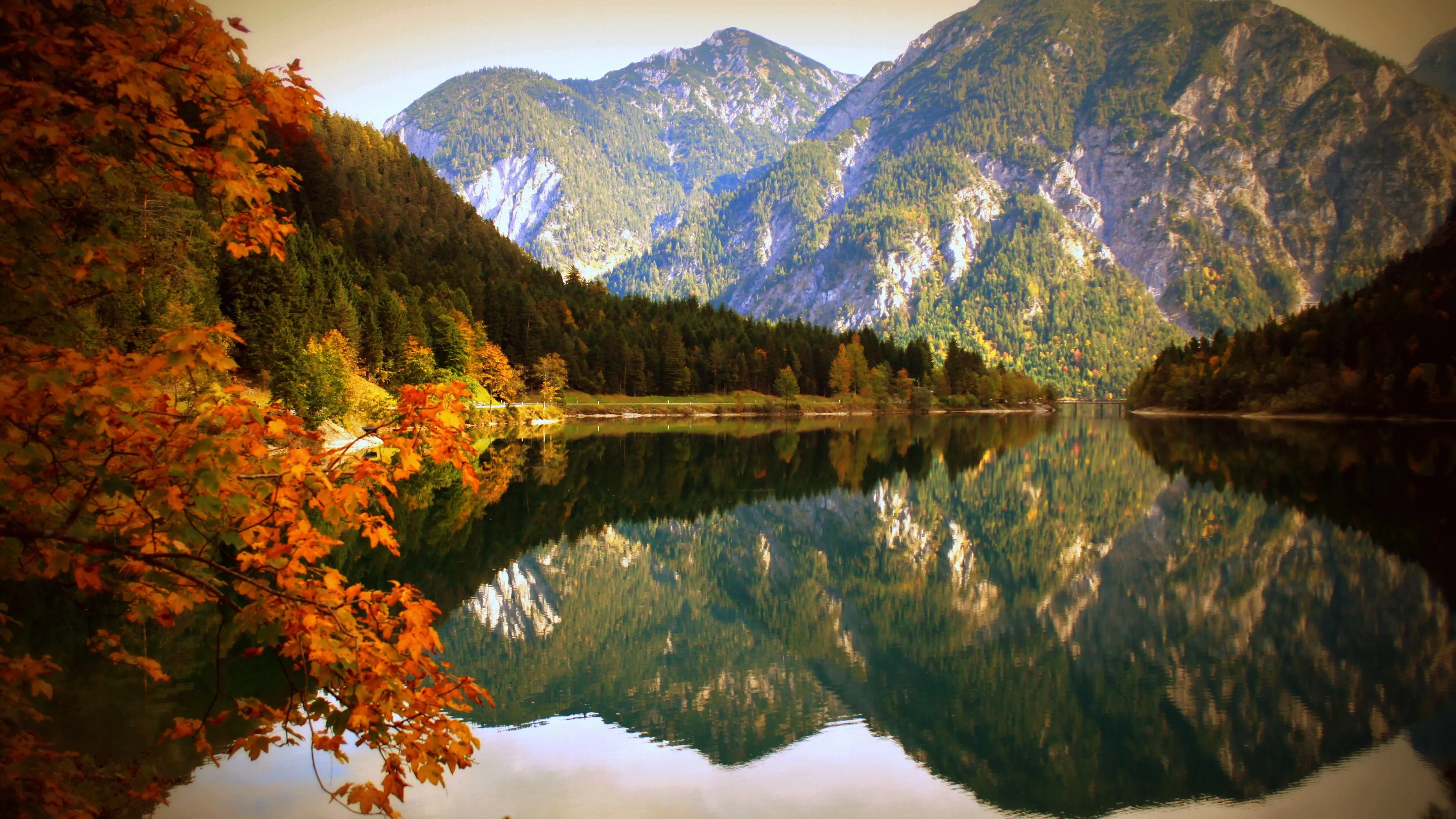 Mountain Lake Reflects Autumn Trees and Rocky Peaks