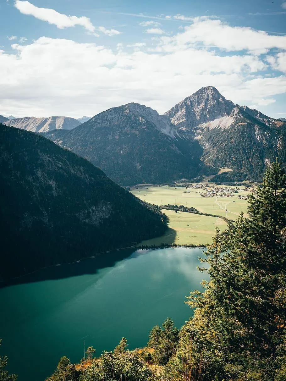 Mountain Lake with Blue Sky and Green Trees in Background