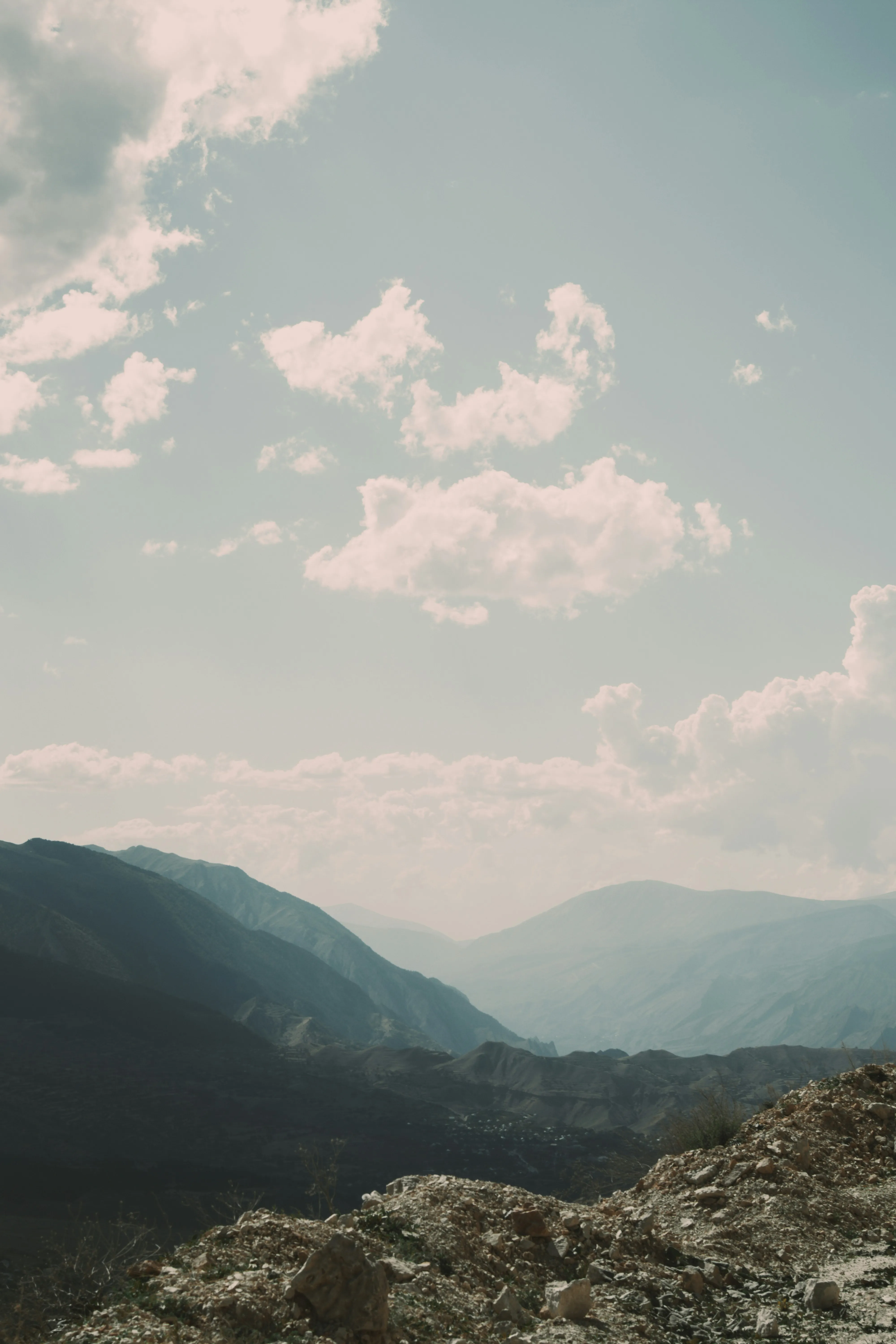 Mountain Landscape Under Bright Sky with Soft Clouds