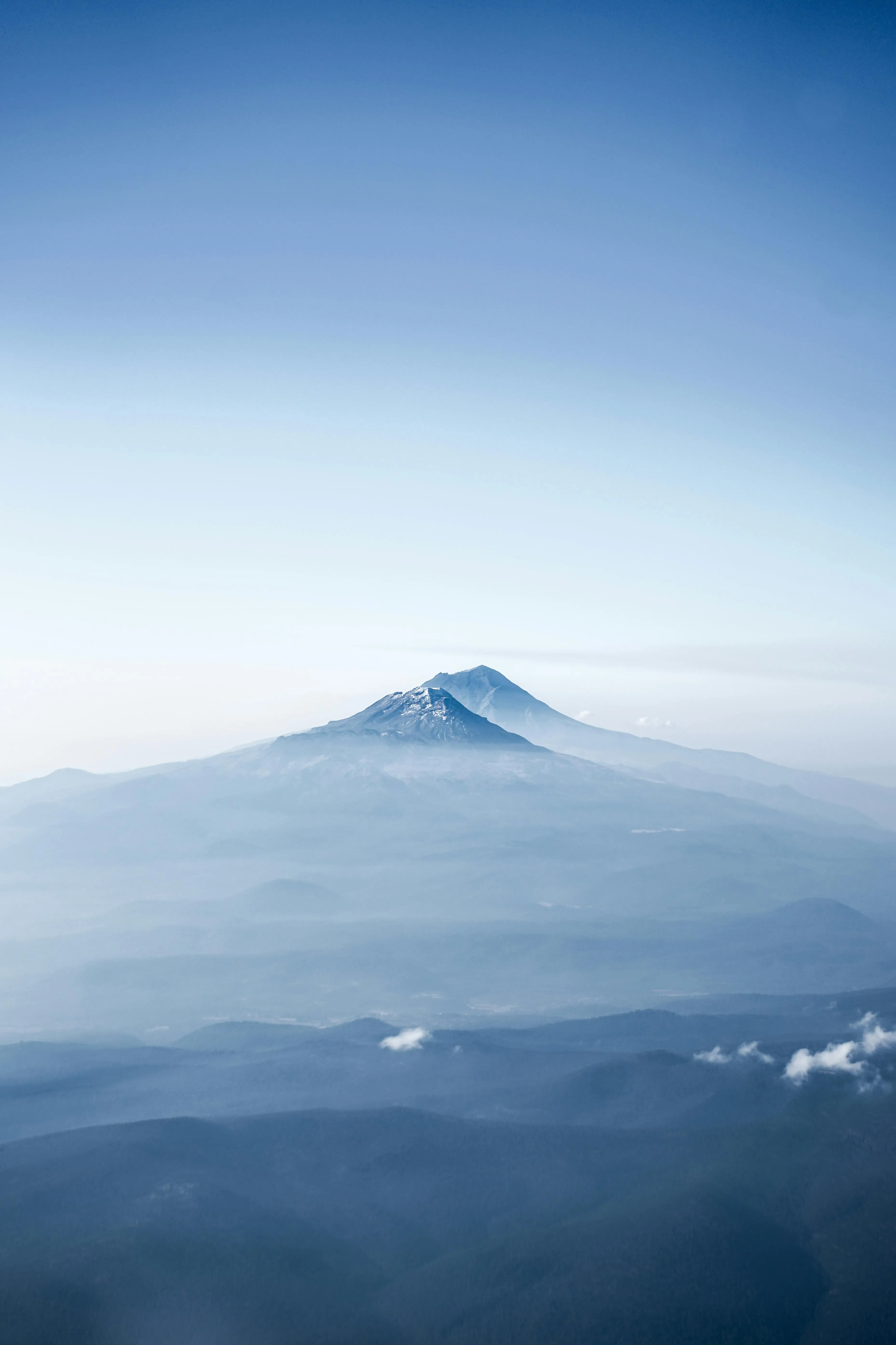 Mountain Peak Rising Above Mist and Blue Sky Image