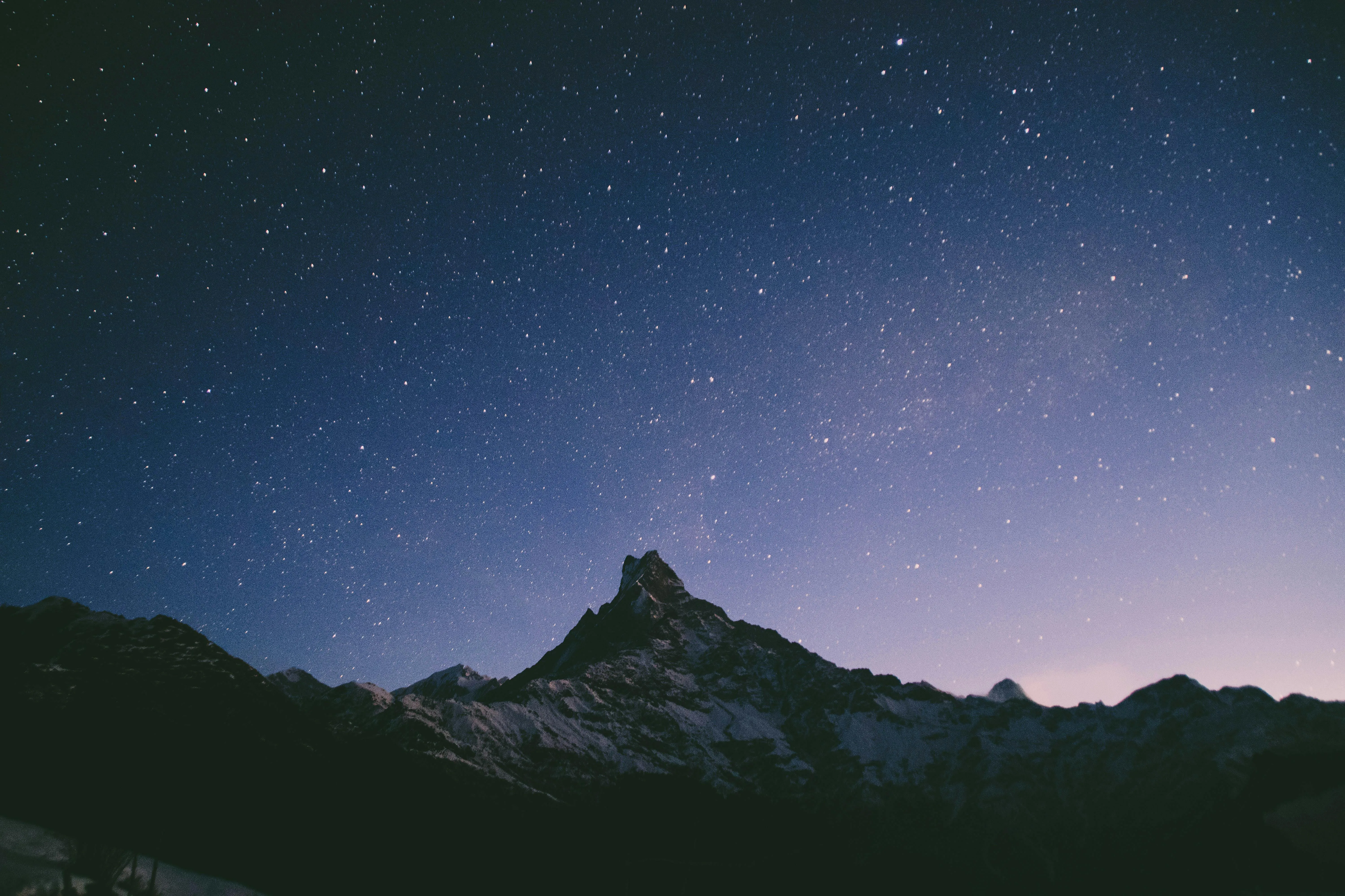 Mountain Peak Silhouetted Against Clear Starry Night Sky