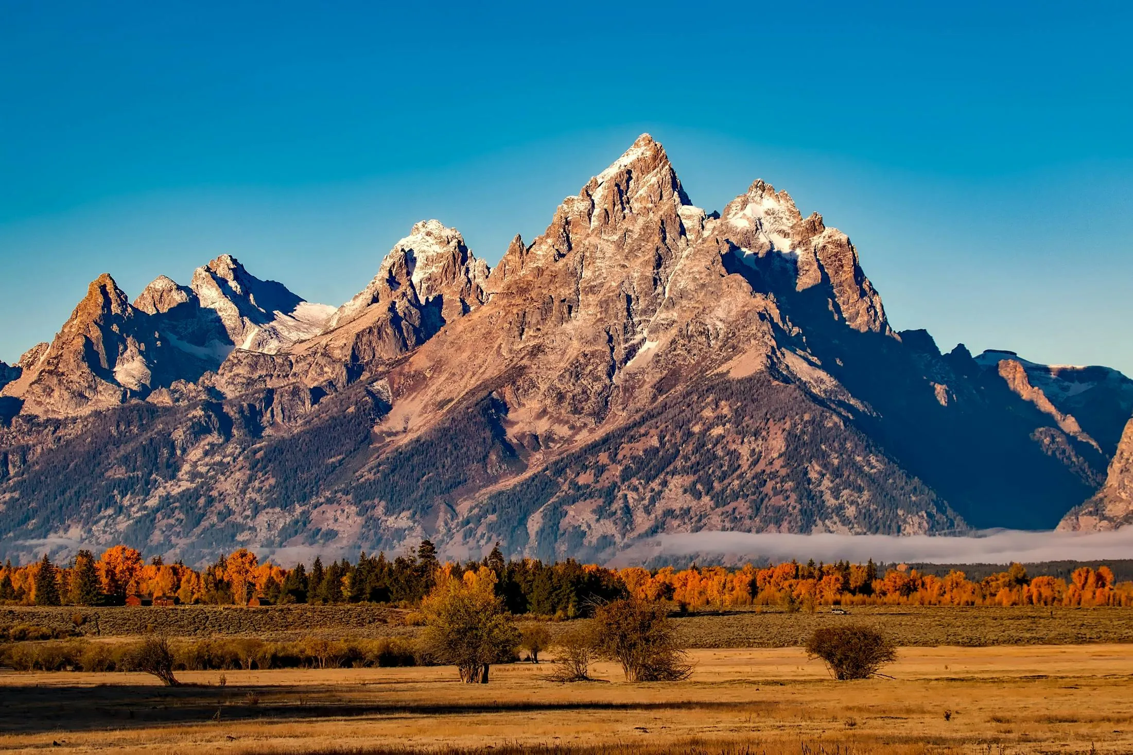 Mountain Peaks Under a Clear Sky with Clouds Wallpaper